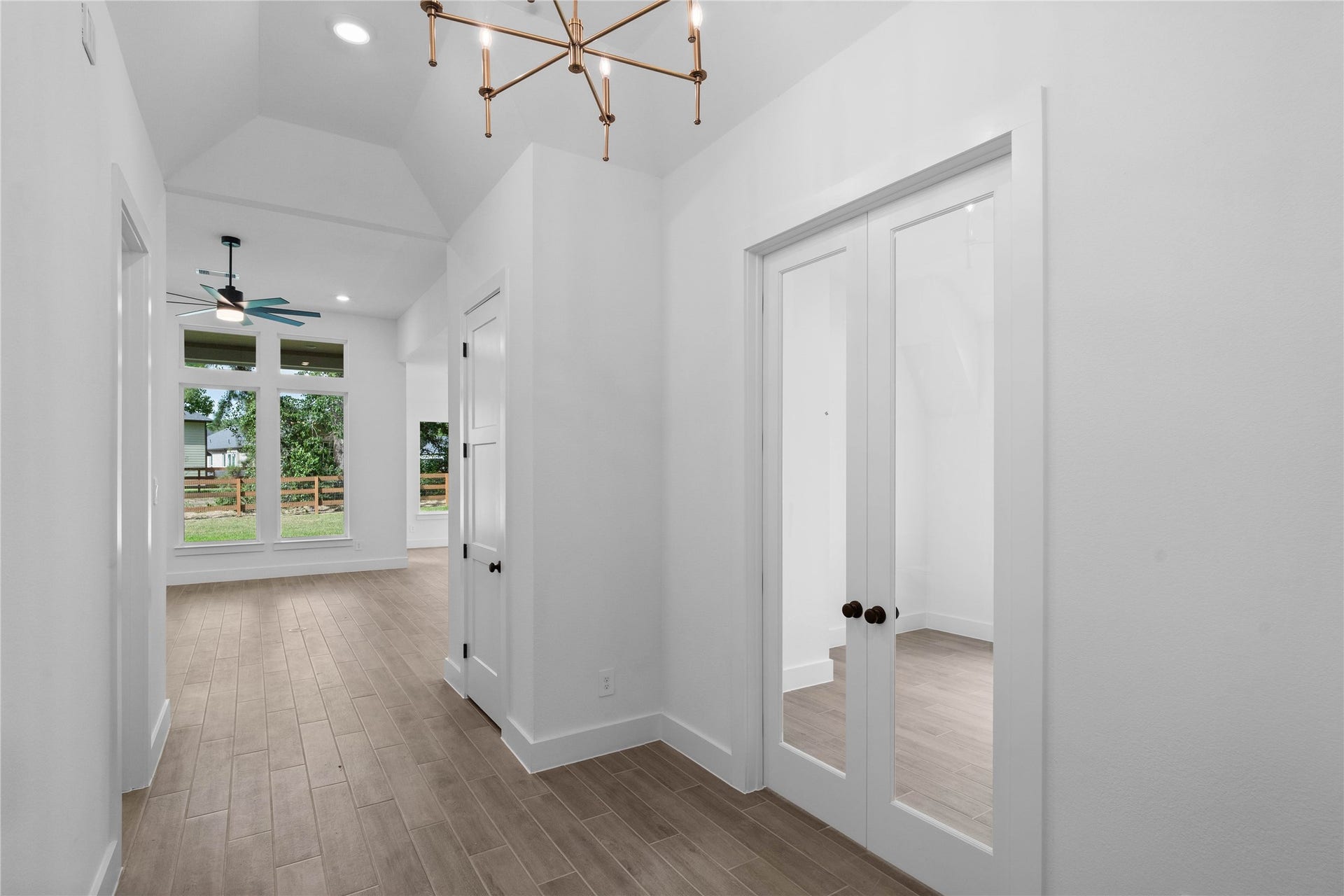 17728 Gold Saddle Lane, Magnolia, TX 77354 This elegant main hallway transitions beautifully into a dedicated home office, highlighted by sophisticated glass French doors that blend privacy with an open, airy feel.