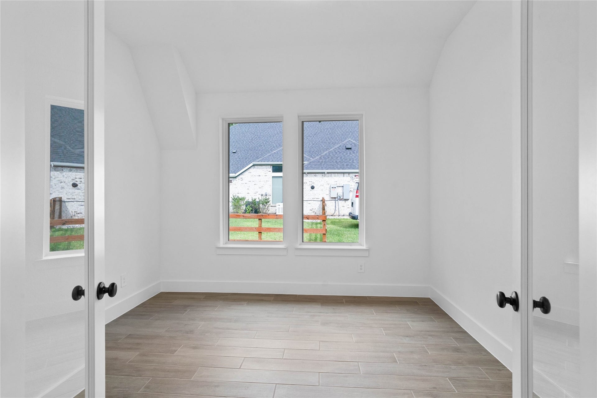 17728 Gold Saddle Lane, Magnolia, TX 77354 Framed by elegant French doors, this bright study offers a quiet, sophisticated space to work from home, defined by a distinct sloped ceiling that adds architectural character.