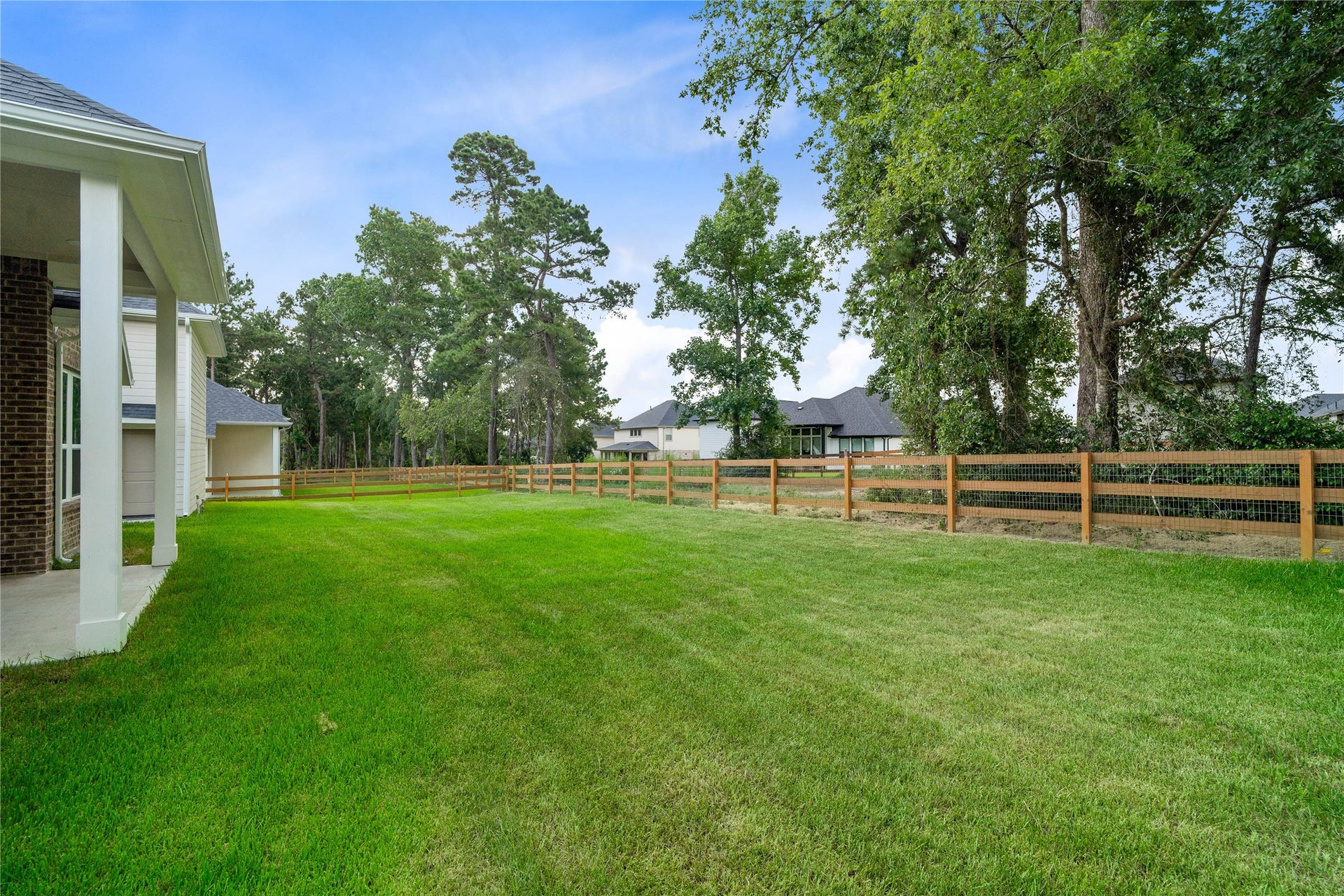 17728 Gold Saddle Lane, Magnolia, TX 77354 The backyard offers a serene and private outdoor oasis. It features a well-manicured lawn, wood ranch fencing, and mature trees that deliver exceptional privacy, natural shade, and a peaceful park-like setting.