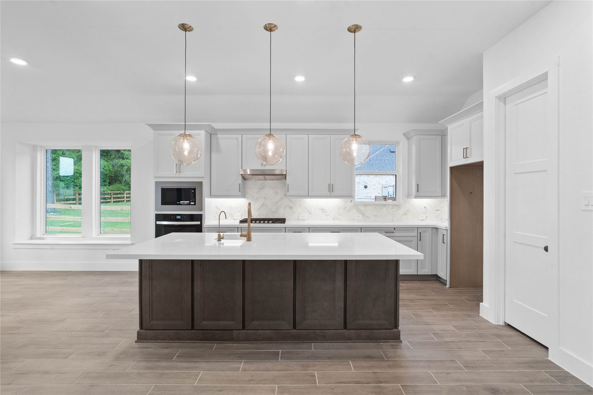 17728 Gold Saddle Lane, Magnolia, TX 77354 This light-filled kitchen balances sleek modernity with warm accents, creating a perfect hub for daily living and entertaining. The expansive island offers ample prep and dining space, complemented by a seamless wall of integrated cabinetry and high-end built-in appliances.