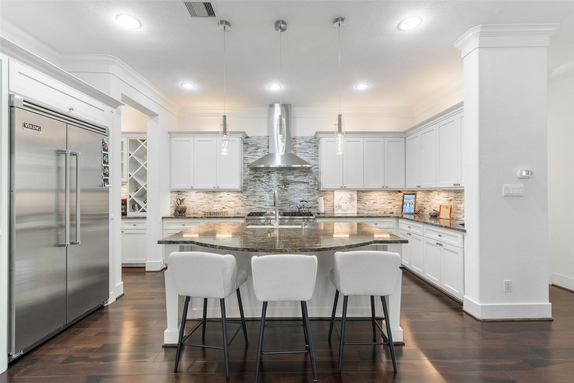 18 Secluded Trail, The Woodlands, TX 77380 LIVING ROOM FLOWS SEAMLESSLY INTO THE SPACIOUS KITCHEN WITH SUBSTANTIAL STONE ISLAND ACCOMPANIED BEAUTIFULLY BY HIGH END STAINLESS VIKING APPLIANCES