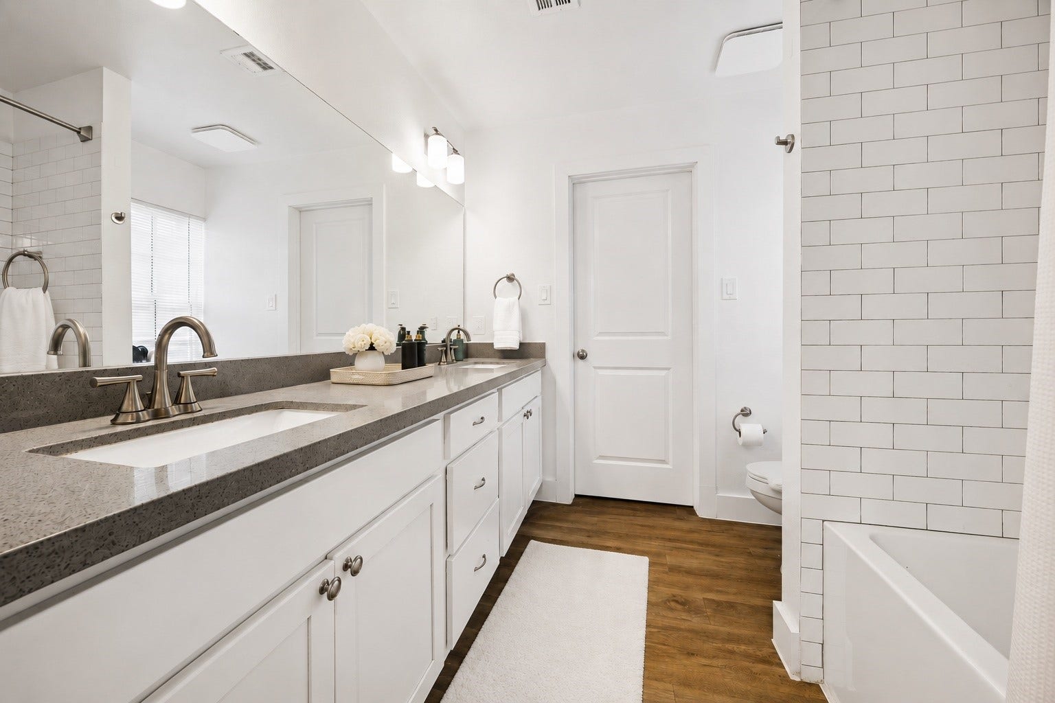 One of the Two Full elegant bathrooms in the First Front unit equipped with double sinks and tub/shower