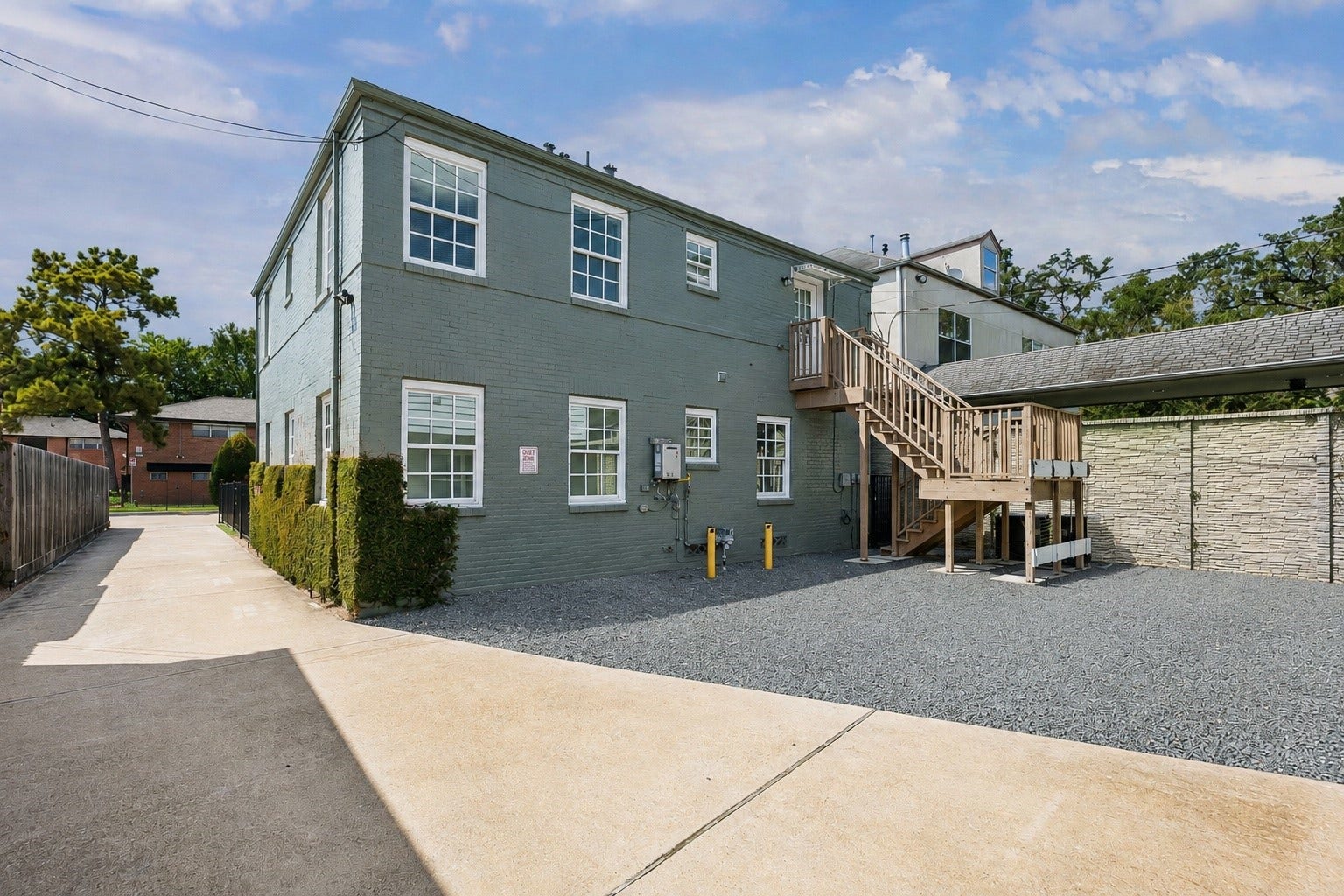 Rear exterior view of the property featuring a dedicated off-street parking and private external access via staircase to the second floor unit