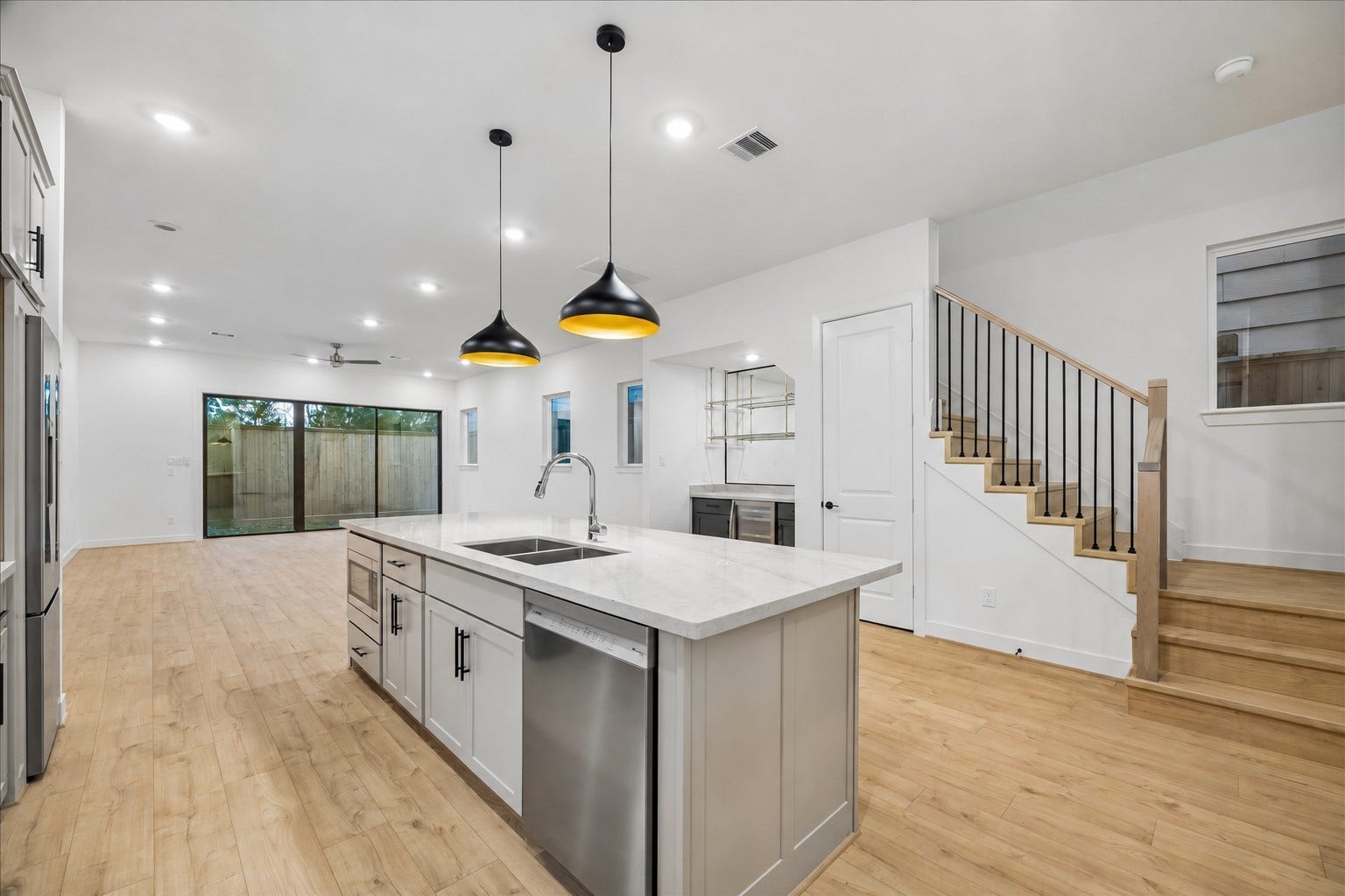 Spacious open-concept kitchen featuring an oversized island, modern finishes, and a dedicated dry bar area, perfect for entertaining