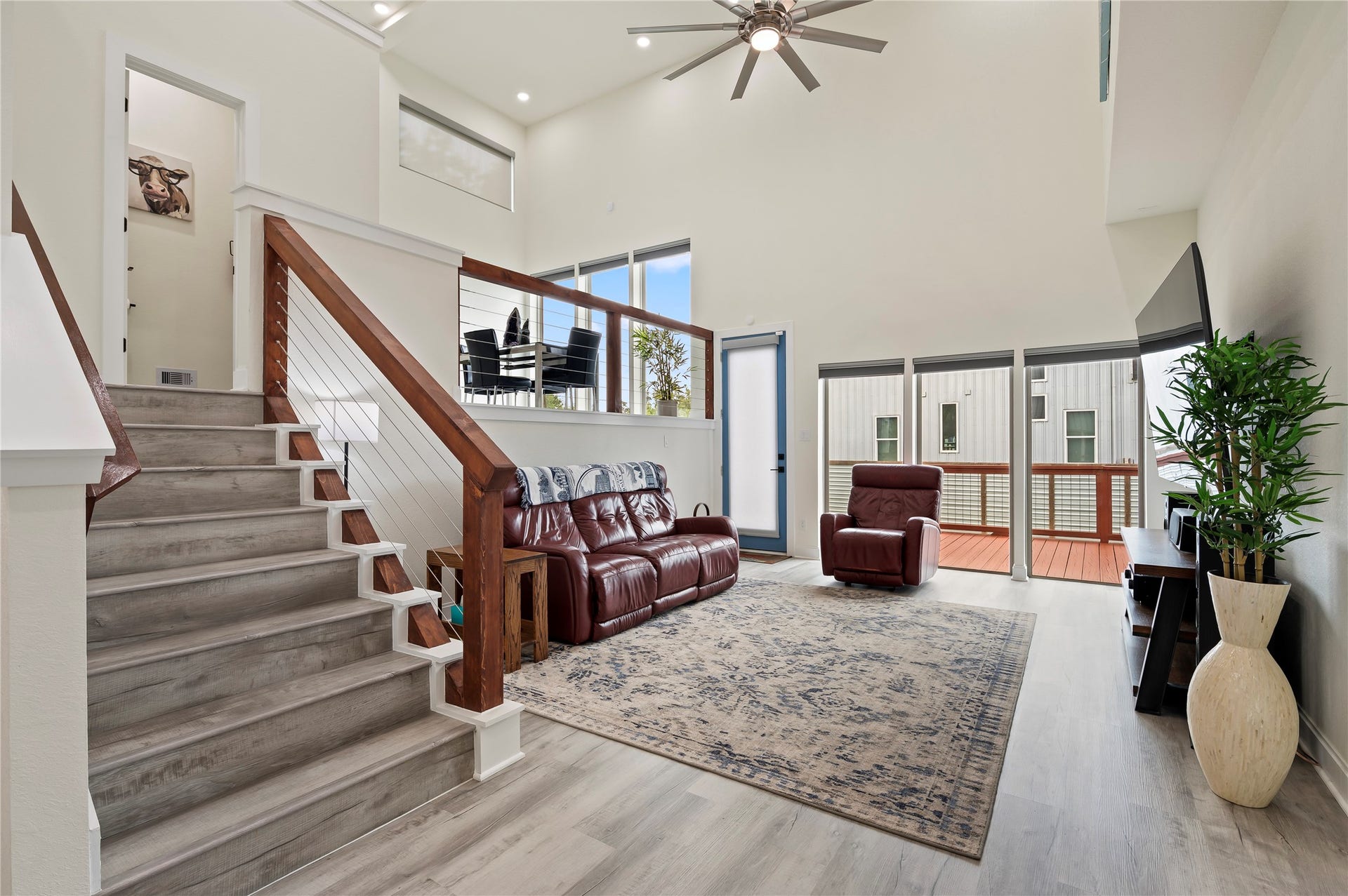 13149 W 6th Street, Santa Fe, TX 77510 Spacious living room features high ceilings spans 20-feet high, COREtec Pro Plus Vinyl Plank in Chesapeake Oak and upscale dual directional up/down blinds, lowered from the top and raised from the bottom simultaneously or separately.