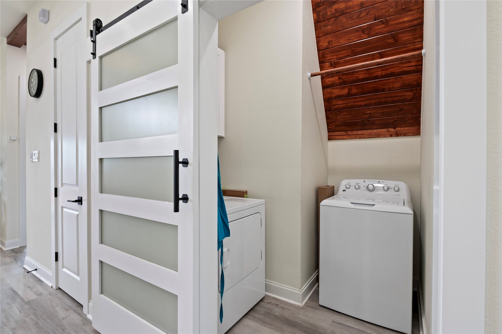 13149 W 6th Street, Santa Fe, TX 77510 Full size laundry closet with modern sliding barn door, storage cabinet and cedar plank accent wall.