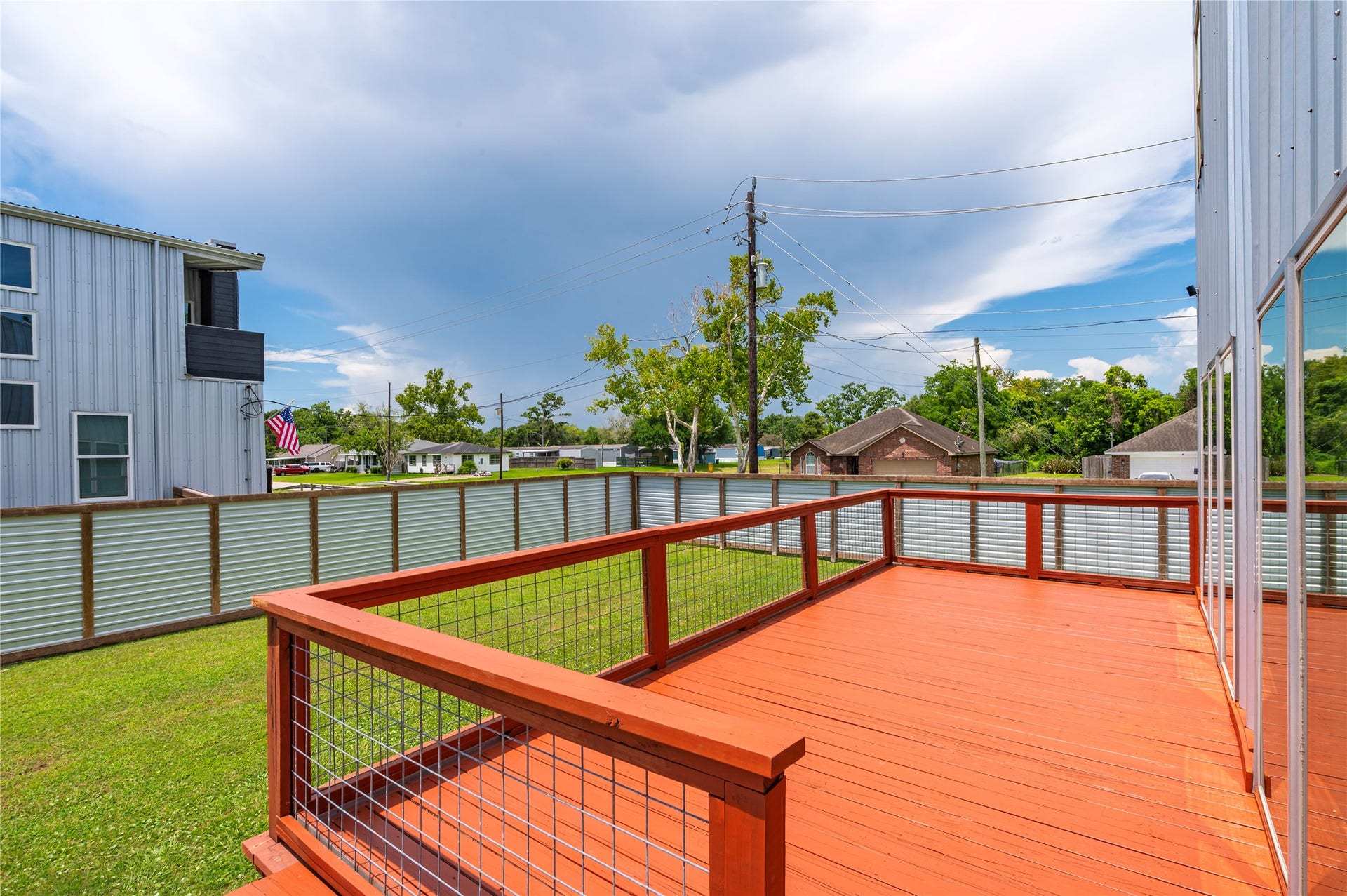 13149 W 6th Street, Santa Fe, TX 77510 Oversized raised back wooden deck features horizontal cable railing and dusk to dawn step accent lights.