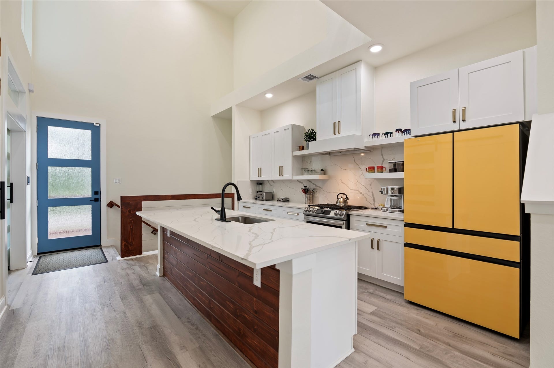 13149 W 6th Street, Santa Fe, TX 77510 Stunning Quartz kitchen island with cedar plank accent wall. Stainless steel Samsung Bespoke Dishwasher and Gas Range; side by side Refrigerator.
