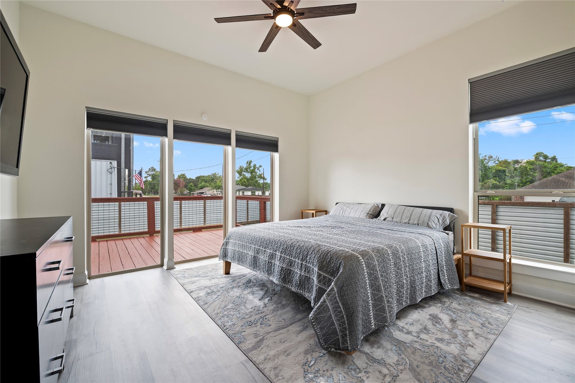 13149 W 6th Street, Santa Fe, TX 77510 Stunning primary bedroom downstairs with 10' ceilings, COREtec Pro Plus Vinyl Plank flooring in Chesapeake Oak, Sherwin Willams Swiss Coffee paint and dual directional up/down blinds, lowered from the top and raised from the bottom simultaneously or separately.