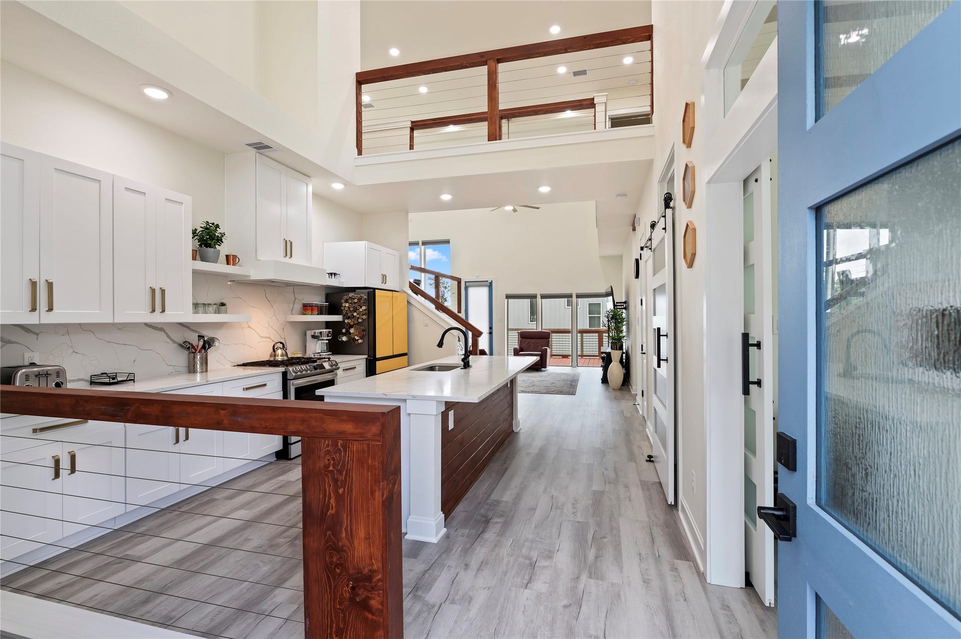 13149 W 6th Street, Santa Fe, TX 77510 Inviting entrance with 20' ceilings in kitchen, family room and dining area. Coated horizontal cable stairways and catwalk with cedar railing throughout.