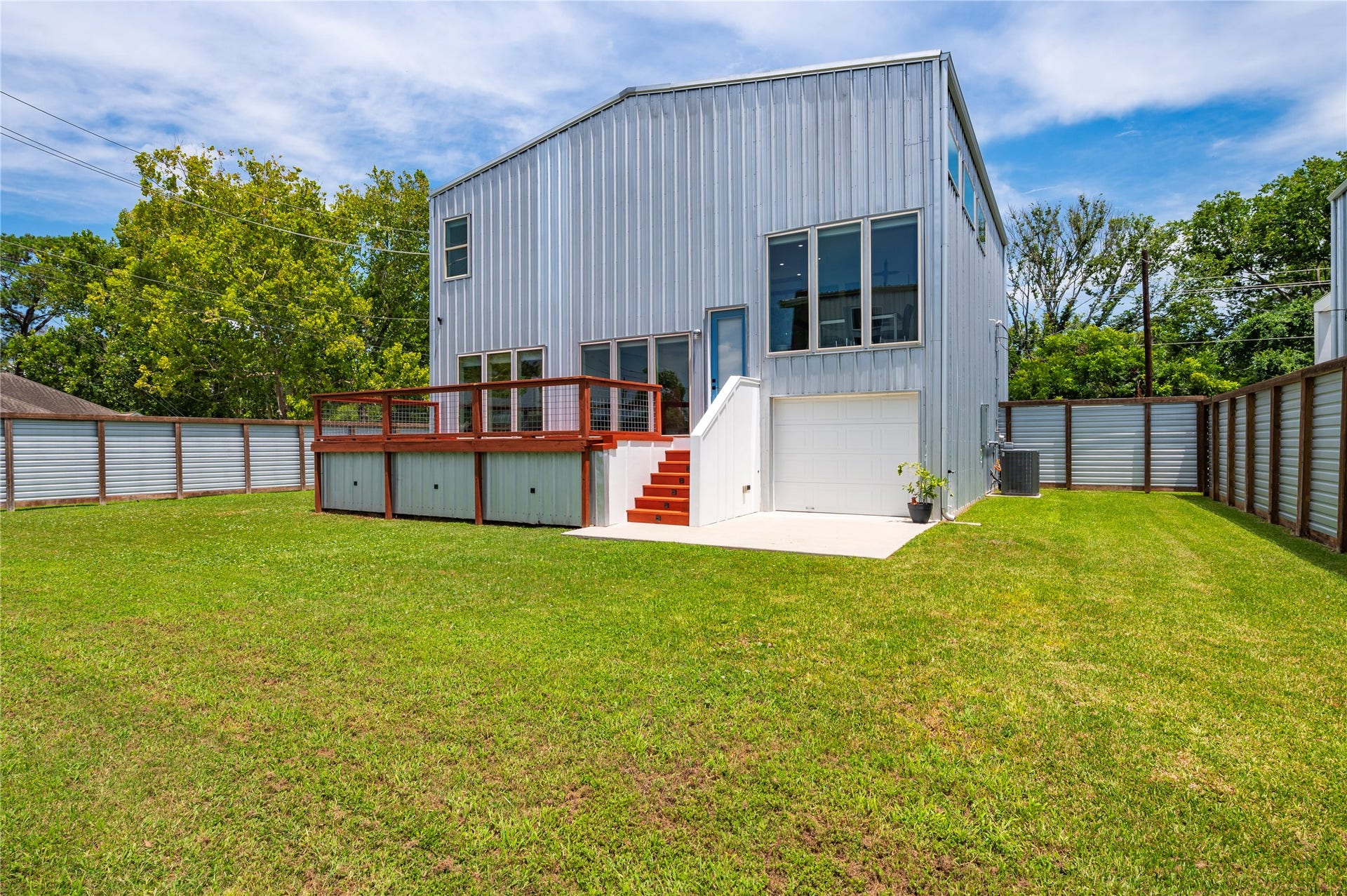 13149 W 6th Street, Santa Fe, TX 77510 Back of the home with garage door and cement deck.