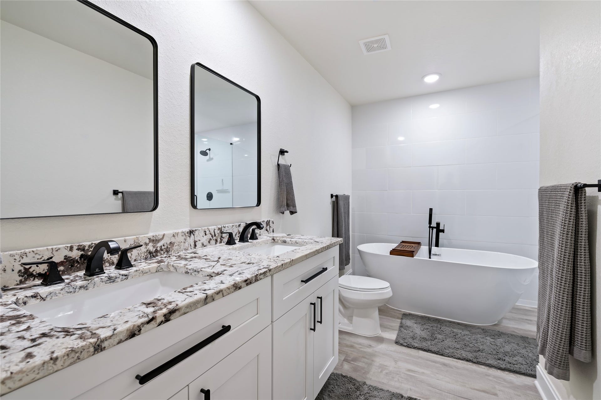 13149 W 6th Street, Santa Fe, TX 77510 Upstairs full bathroom features large soaking tub with separate shower, Alaskan White Granite countertops with custom hardware, ample storage drawers and dual vanities with framed mirrors.