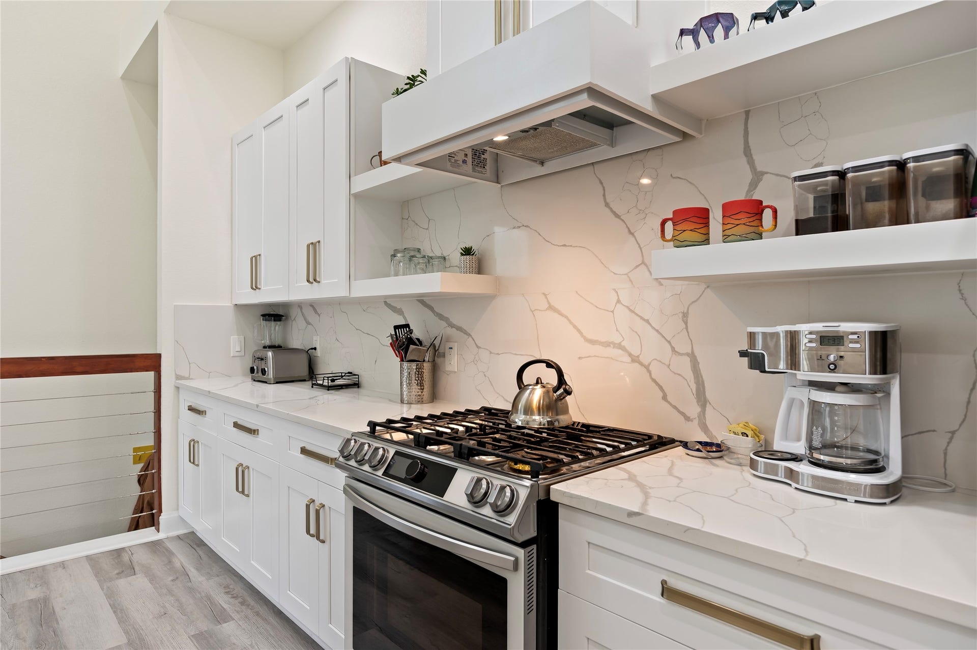 13149 W 6th Street, Santa Fe, TX 77510 5-burner Samsung gas range and overhead venthood. White Shaker cabinets throughout with custom art display shelves.