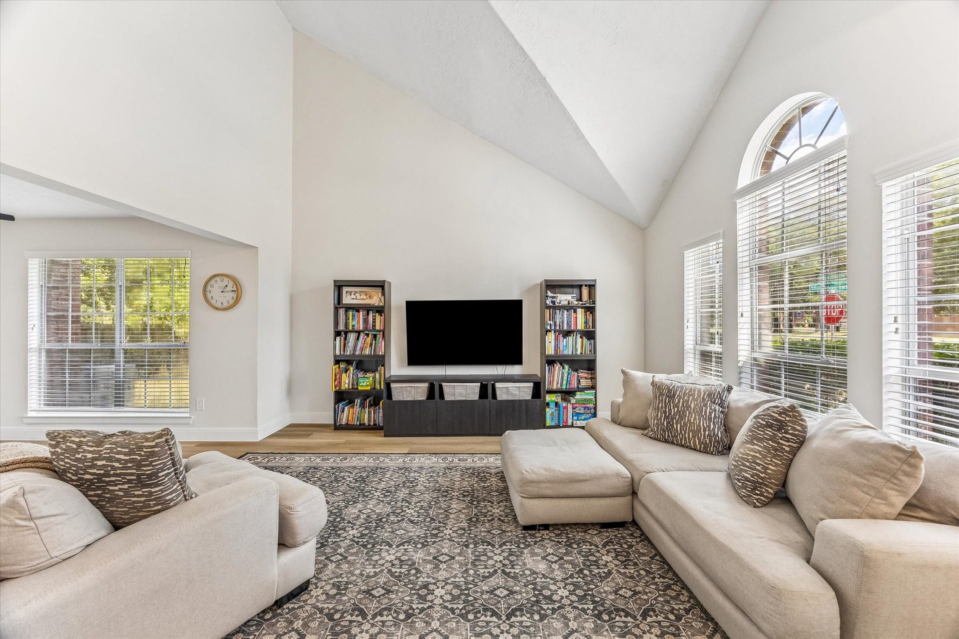 1043 Danforth Drive, Houston, TX 77062 Spacious living room with vaulted ceilings, large windows for natural light, and a cozy seating area perfect for relaxation and entertainment.