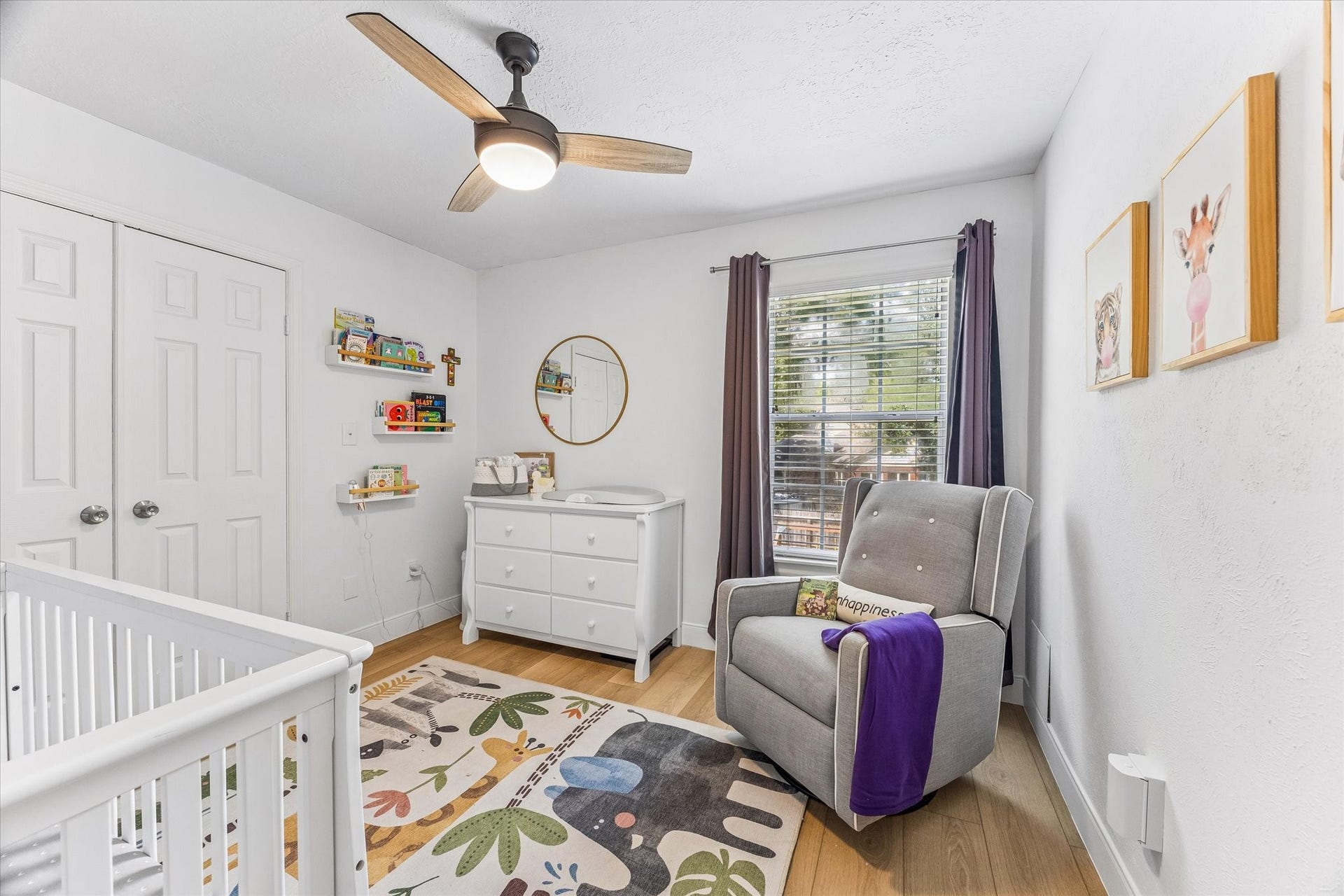 1043 Danforth Drive, Houston, TX 77062 Charming nursery with a cozy rocking chair, vibrant animal-themed rug, and ample natural light, perfect for creating a serene space for your little one.