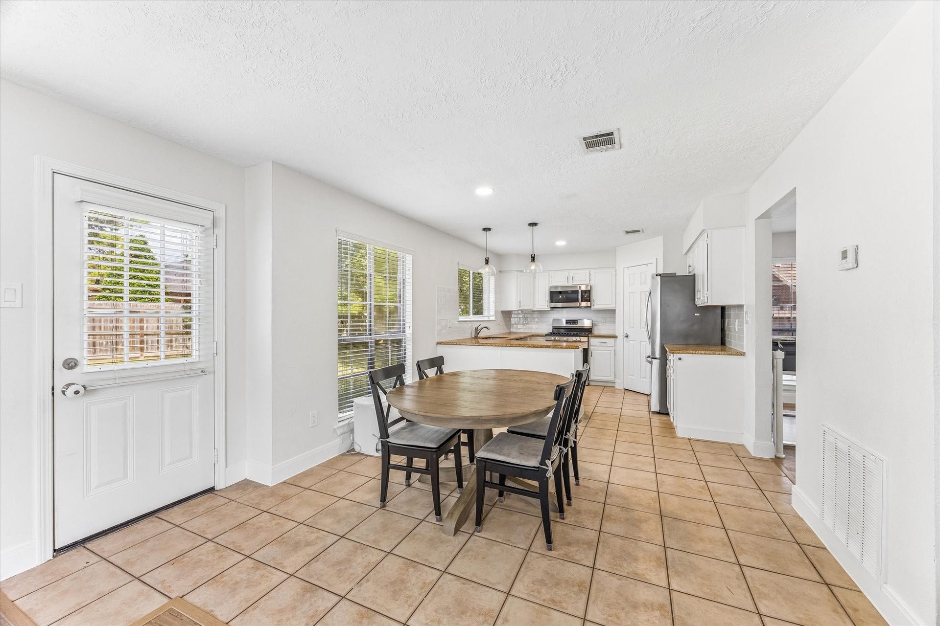1043 Danforth Drive, Houston, TX 77062 Bright and spacious kitchen with modern appliances, tile flooring, and a cozy dining area, perfect for family gatherings.