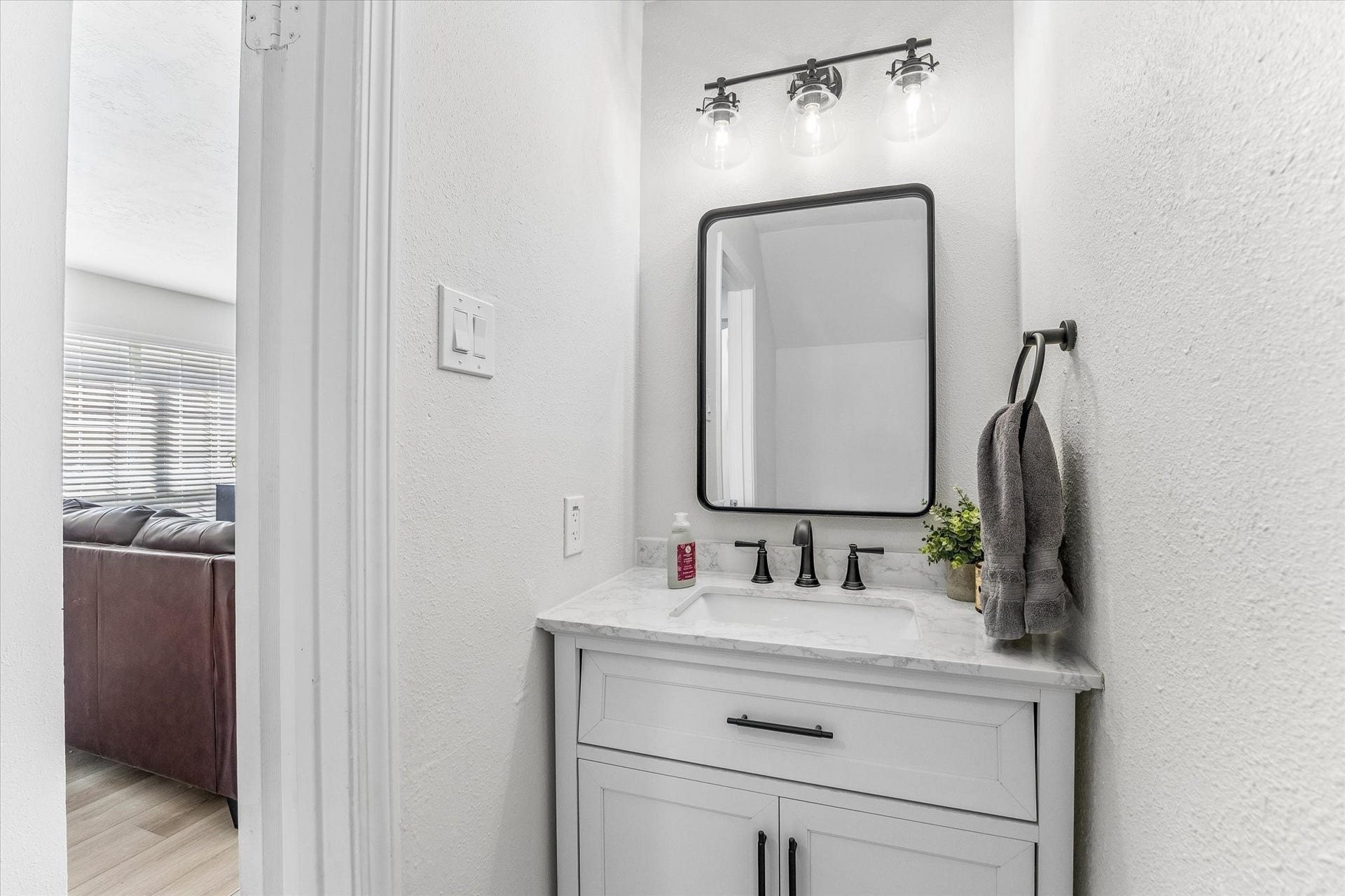 1043 Danforth Drive, Houston, TX 77062 Charming powder room with a sleek vanity, modern fixtures, and stylish lighting, seamlessly connected to a cozy living area.