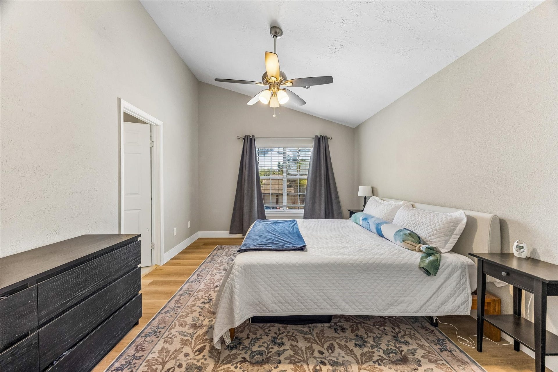 1043 Danforth Drive, Houston, TX 77062 Spacious primary 15x11 bedroom with vaulted ceiling, natural light, and a cozy atmosphere featuring a ceiling fan and elegant decor.