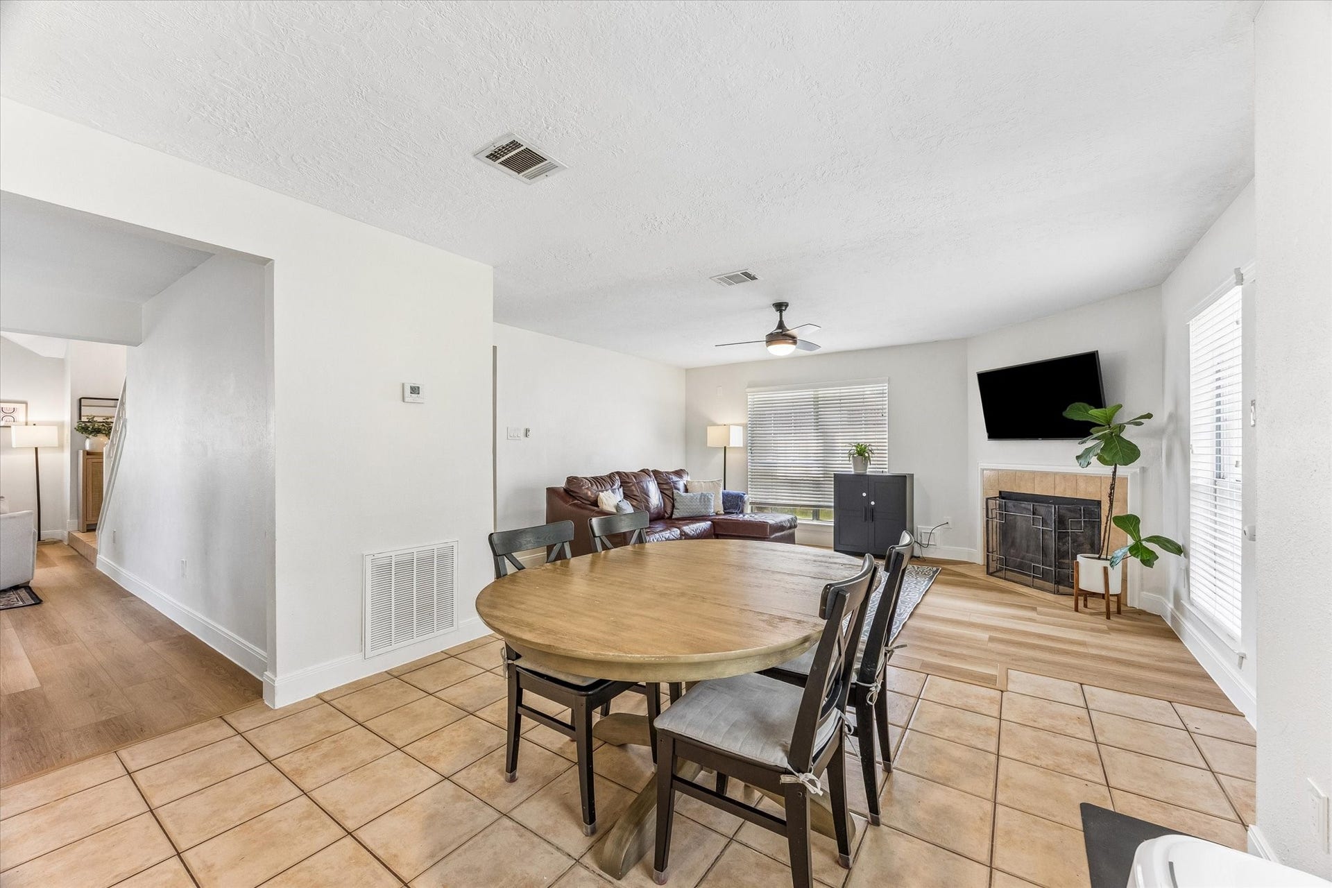 1043 Danforth Drive, Houston, TX 77062 Bright and inviting open-concept living area featuring a cozy corner fireplace, modern ceiling fan, and ample natural light.