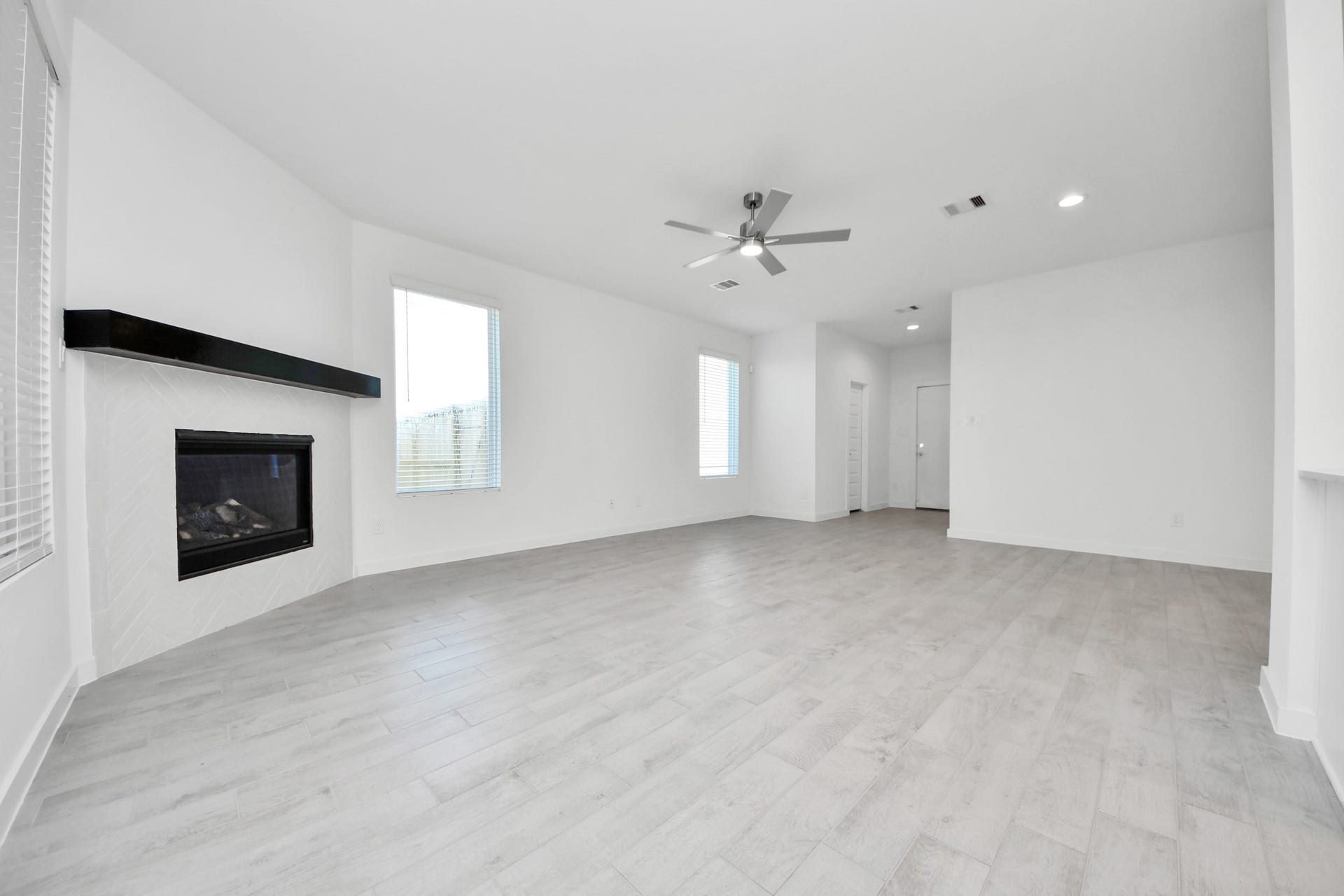 Family room flooded with natural light through the expansive windows.  The premium tile flooring adds a touch of luxury to the space, creating the perfect setting for relaxing moments and cherished gatherings with loved ones. Sample photo of completed home with similar floor plan. Actual colors and selections may vary.