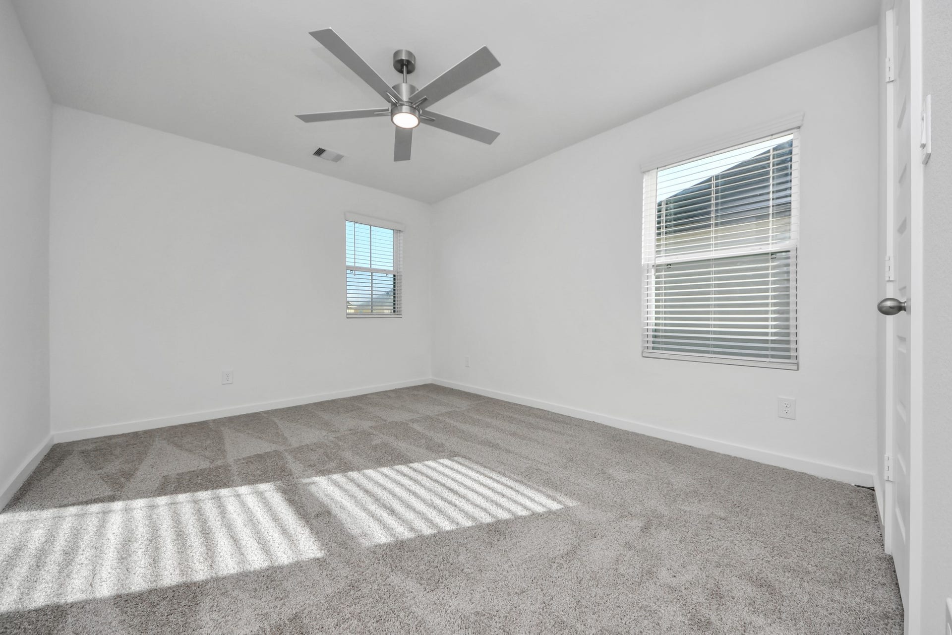 Secondary bedroom features plush carpeting, large windows that let in plenty of natural light, bright paint, and spacious closets. Sample photo of completed home with similar floor plan. Actual colors and selections may vary.