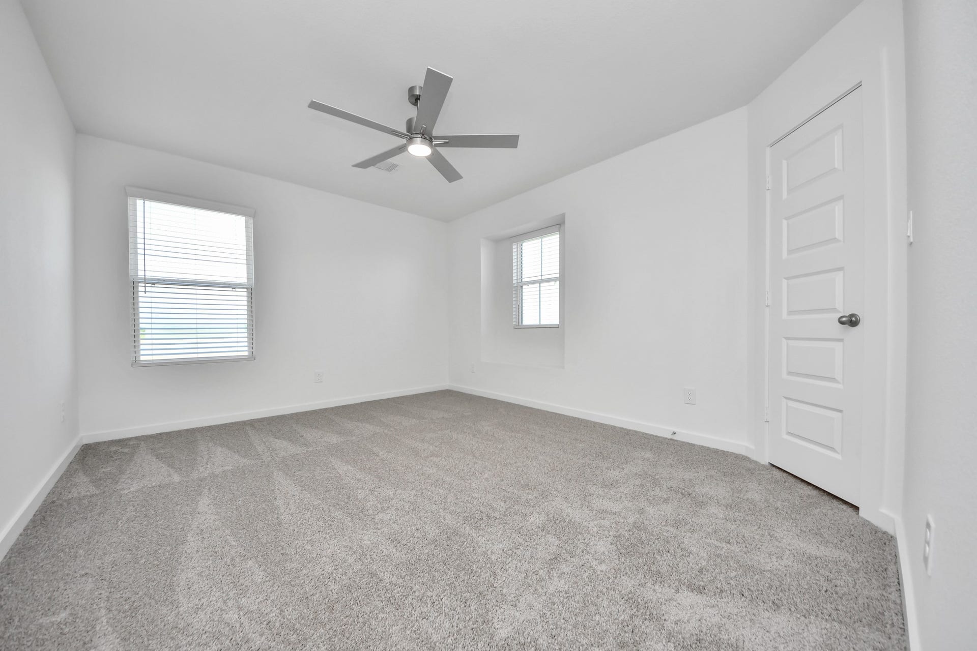 Secondary bedroom features plush carpeting, large windows that let in plenty of natural light, bright paint, and spacious closets. Sample photo of completed home with similar floor plan. Actual colors and selections may vary.
