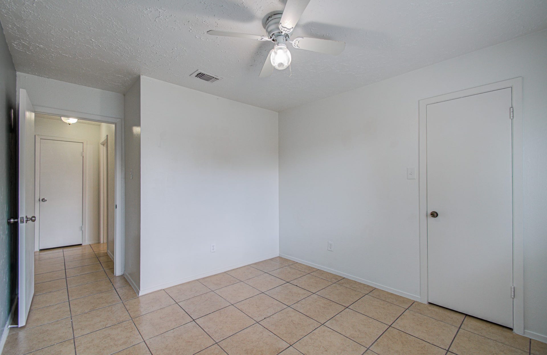 7319 Skybright Lane, Houston, TX 77095 Bright and airy room featuring neutral tile flooring, a ceiling fan for comfort, and ample natural light, offering a versatile space for any purpose.