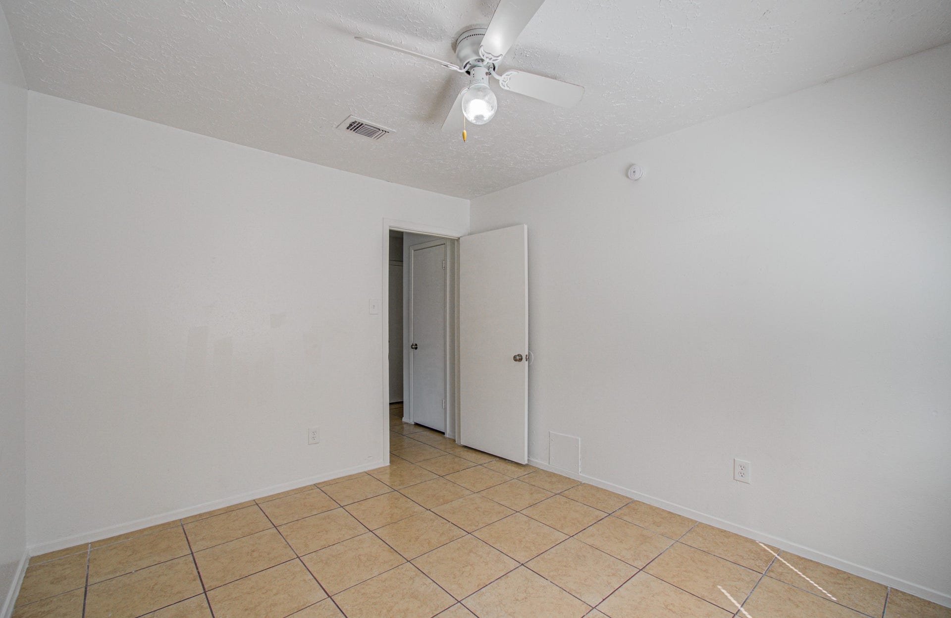 7319 Skybright Lane, Houston, TX 77095 Bright and airy room with neutral tile flooring, crisp white walls, and a ceiling fan, offering a versatile space for any decor style.