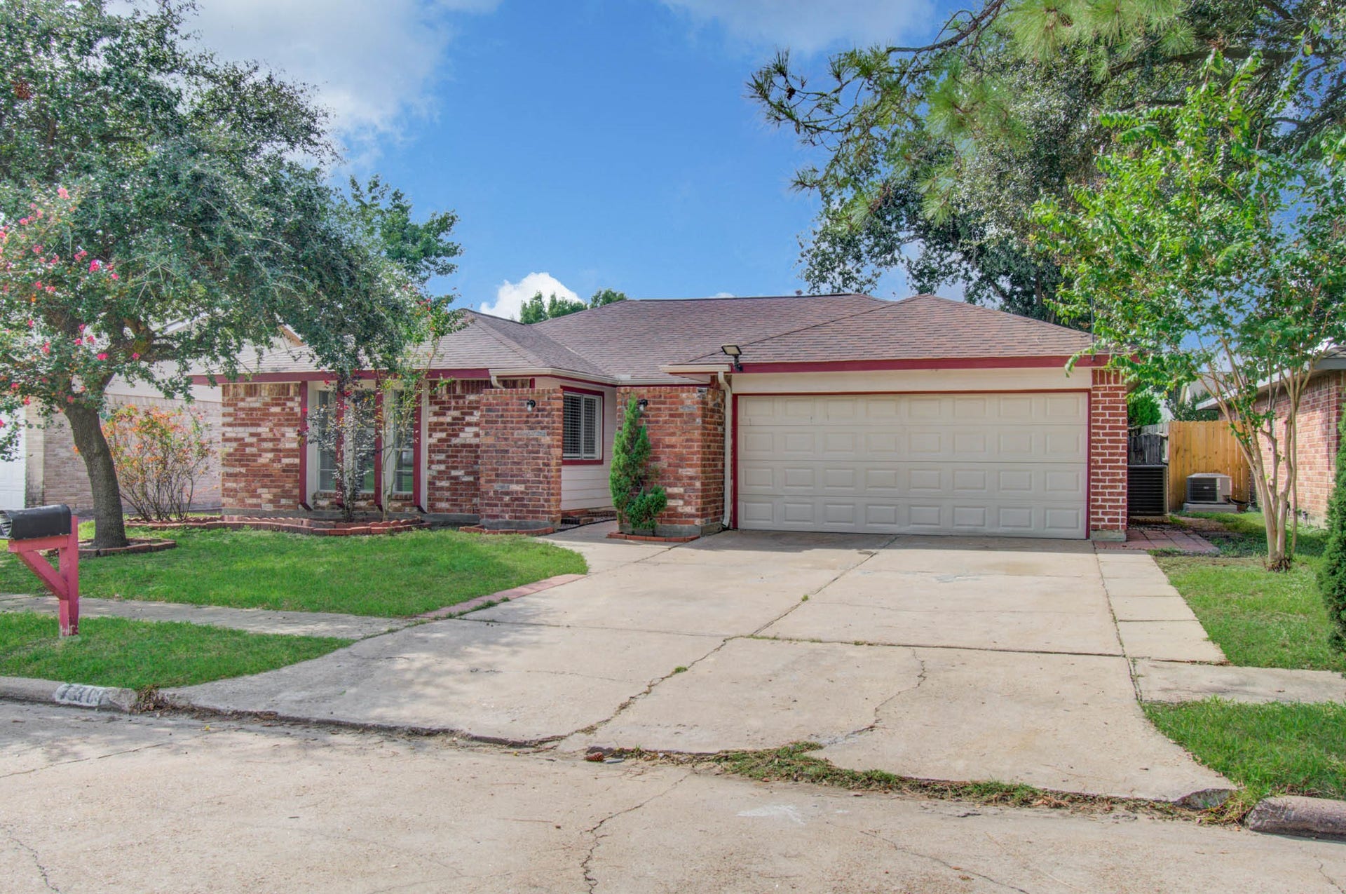 7319 Skybright Lane, Houston, TX 77095 Charming brick home with a spacious two-car garage, nestled on a quiet street, featuring lush green lawns and mature trees for added curb appeal.