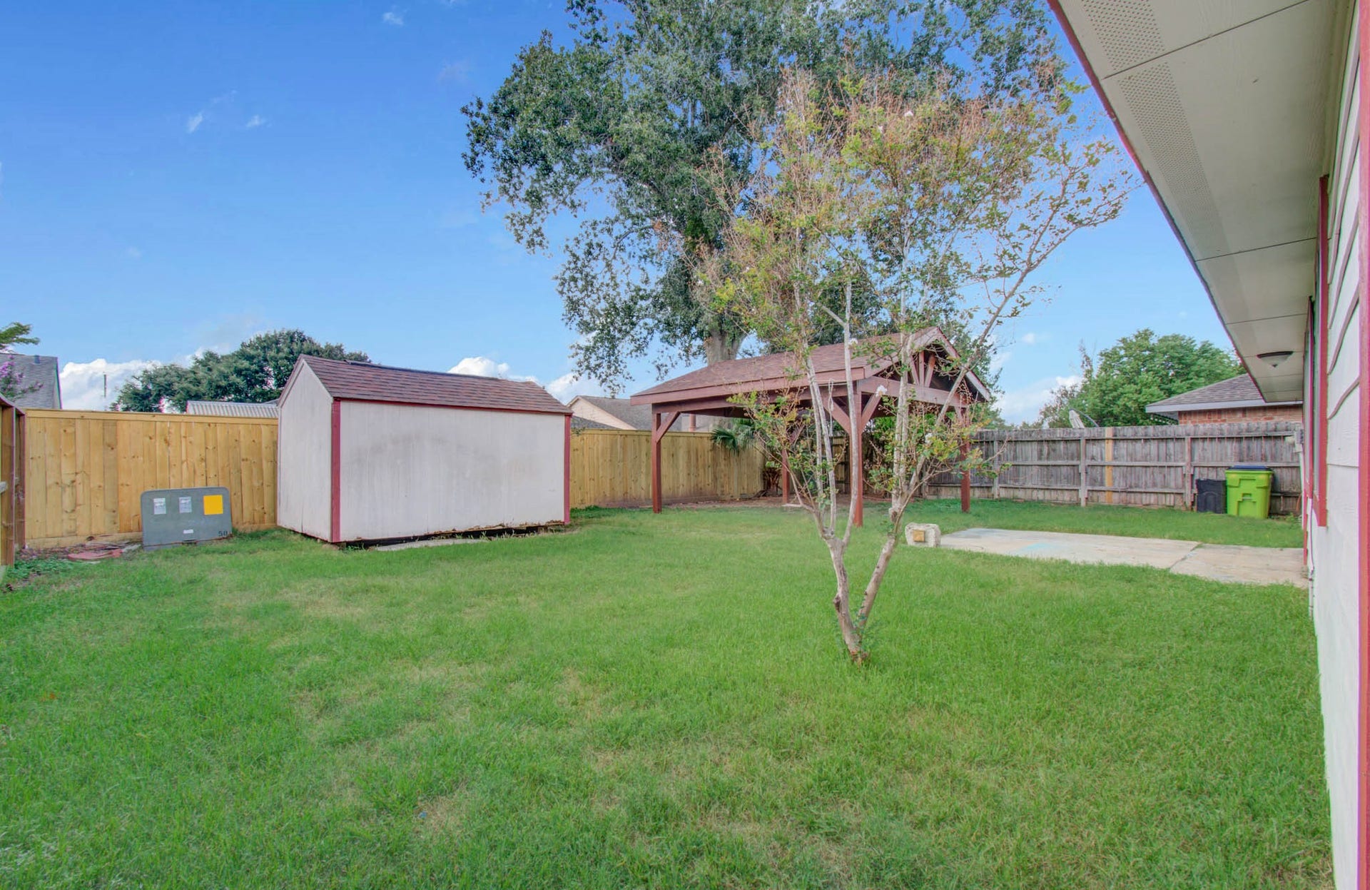 7319 Skybright Lane, Houston, TX 77095 Spacious backyard with lush grass, a convenient storage shed, and a charming gazebo, perfect for outdoor gatherings and relaxation.