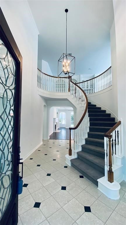 5510 Cherry Creek Bend Court, Houston, TX 77041 Elegant entryway featuring a grand staircase and stylish tile flooring, welcoming you home with sophistication.