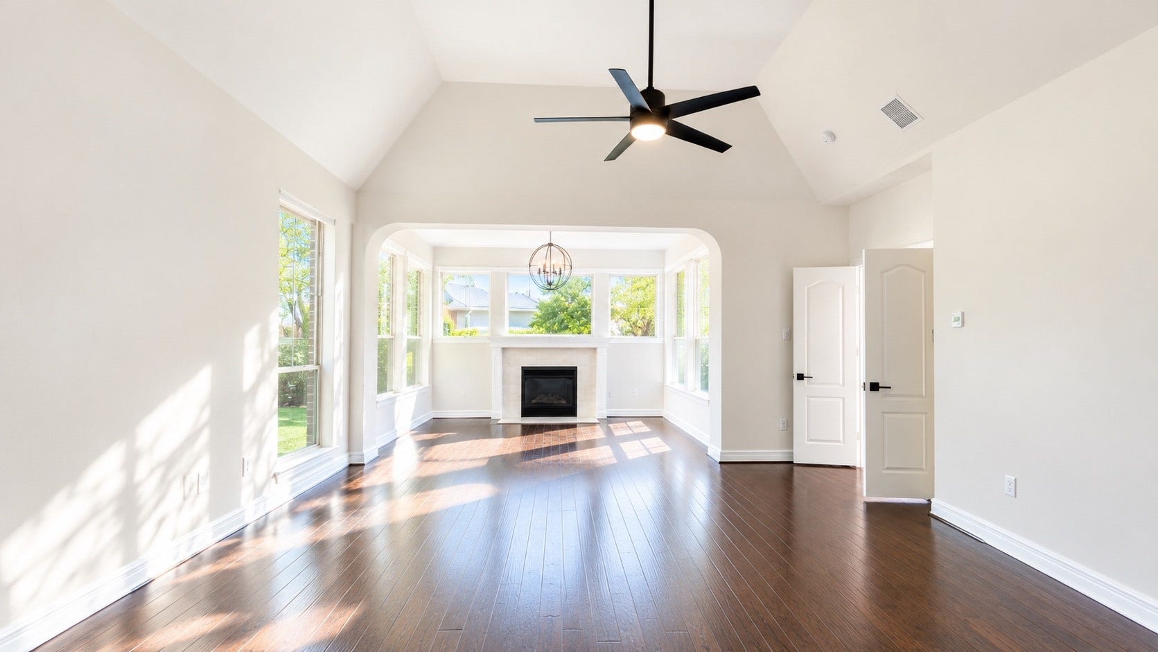 5510 Cherry Creek Bend Court, Houston, TX 77041 Spacious primary bedroom featuring elegant hardwood floors, abundant natural light from large windows, and a cozy fireplace for ultimate comfort.