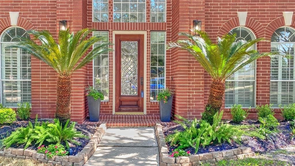 5510 Cherry Creek Bend Court, Houston, TX 77041 Elegant front door framed by lush greenery, offering a warm and inviting entrance.