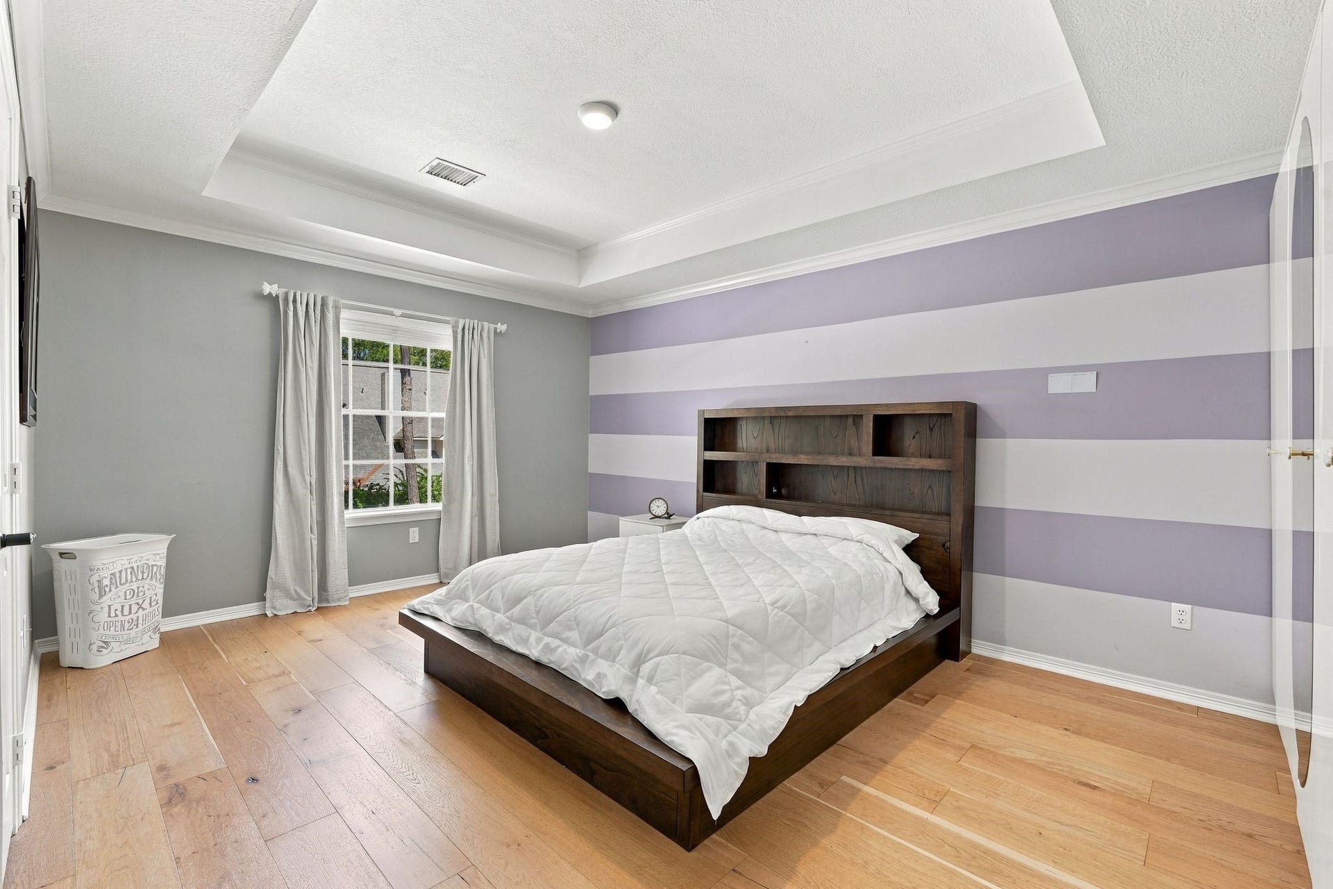 22 Hillside View Place, The Woodlands, TX 77381 Bedroom 2 is generously sized and lives like a second primary suite, with a tray ceiling, hardwood flooring and a private esuite bath and dressing room.