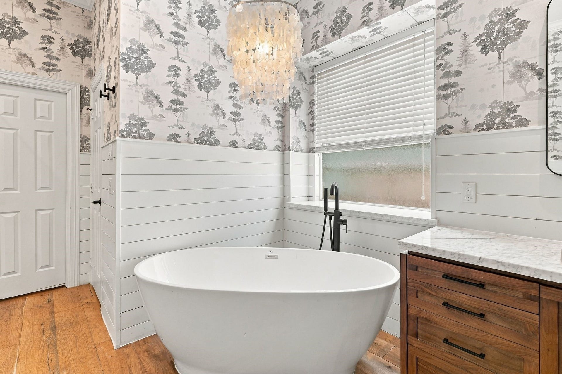 22 Hillside View Place, The Woodlands, TX 77381 Unwind in the freestanding soaking tub surrounded by sophisticated finishes in this beautifully updated primary bathroom.