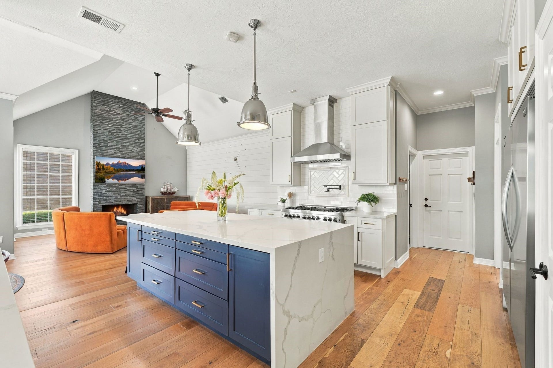 22 Hillside View Place, The Woodlands, TX 77381 The beautifully renovated chef's kitchen features an oversized statement island, quartz countertops, professional style appliances and abundant custom cabinetry.