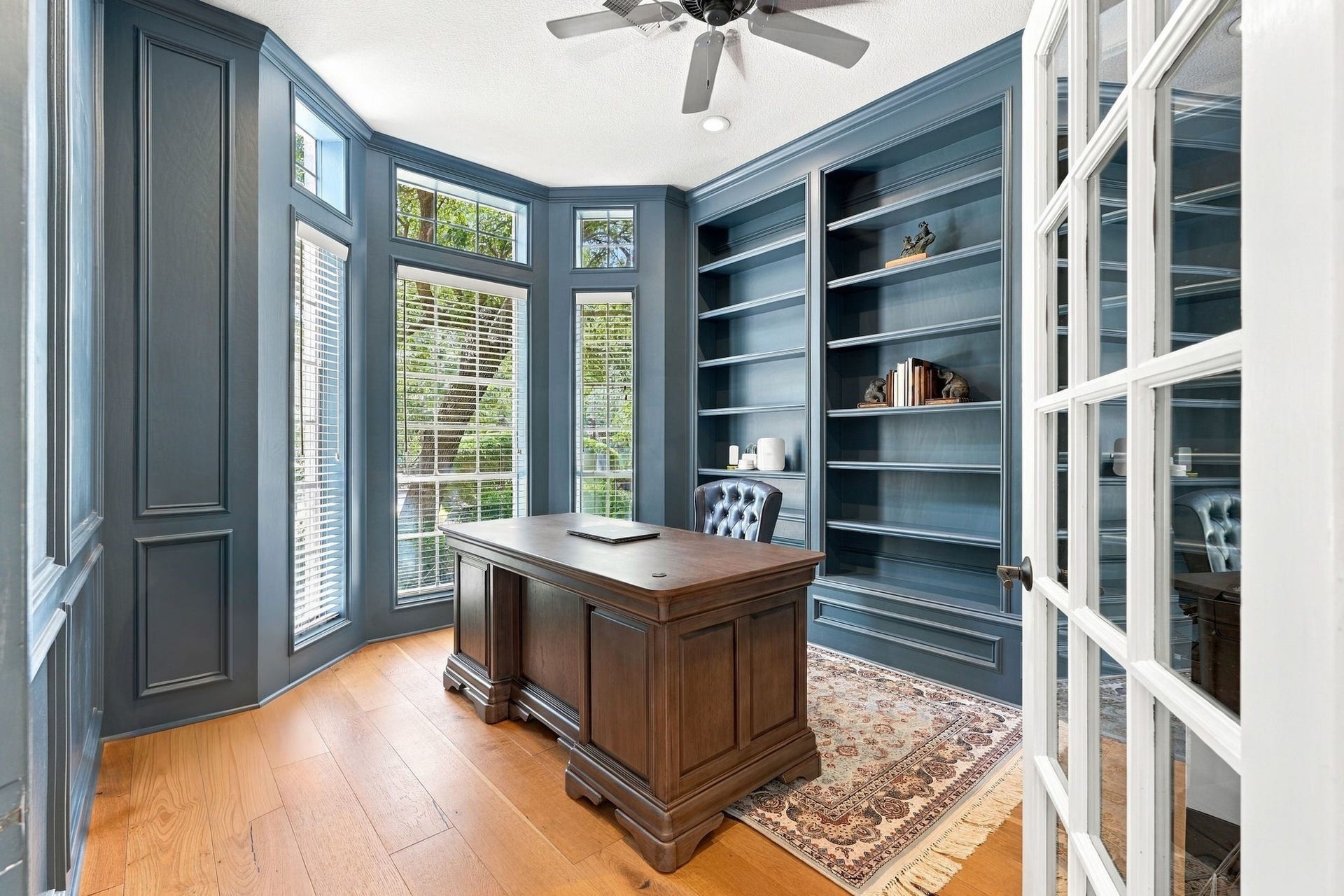 22 Hillside View Place, The Woodlands, TX 77381 The private executive study features custom built-in shelving, rich millwork, hardwood flooring and a beautiful bay window.