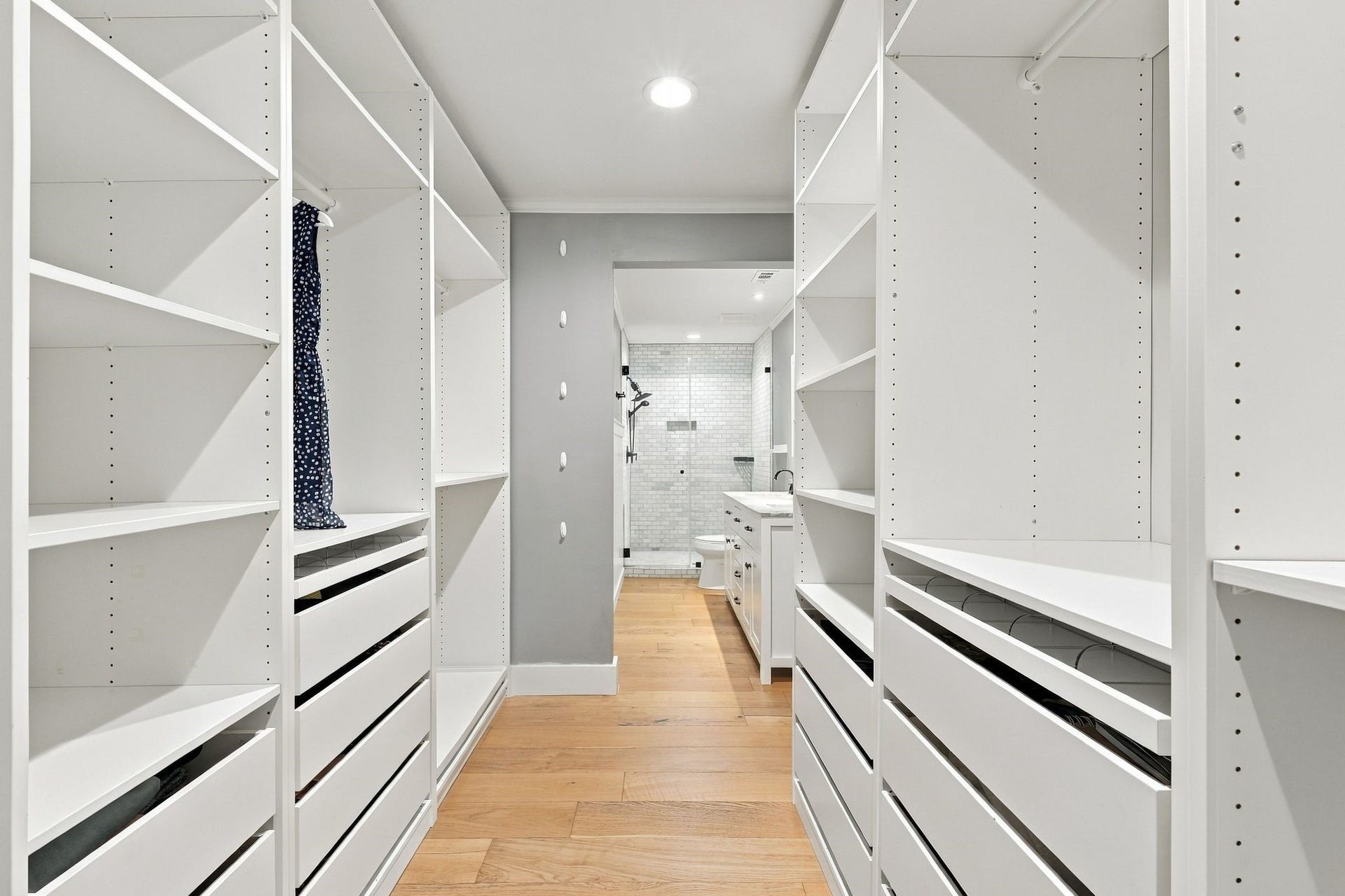 22 Hillside View Place, The Woodlands, TX 77381 An impressive custom walk in closet feels like a luxury dressing room and offer exceptional storage with extensive built in shelving, drawers and shoe racks.