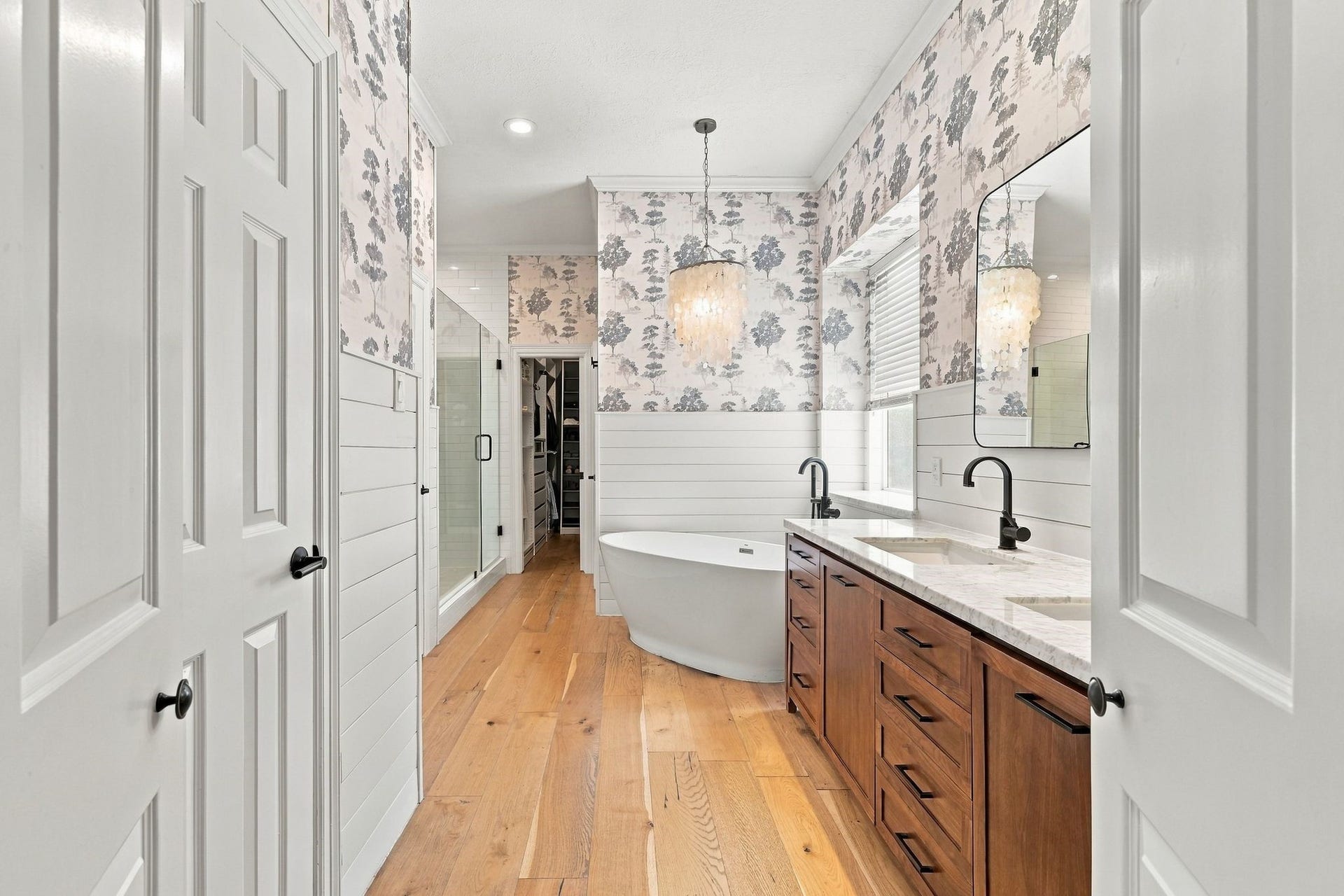22 Hillside View Place, The Woodlands, TX 77381 Beautifully renovated en suite bath creates a serene, spa-like retreat with designer finishes, dual vanities, and a freestanding soaking tub.
