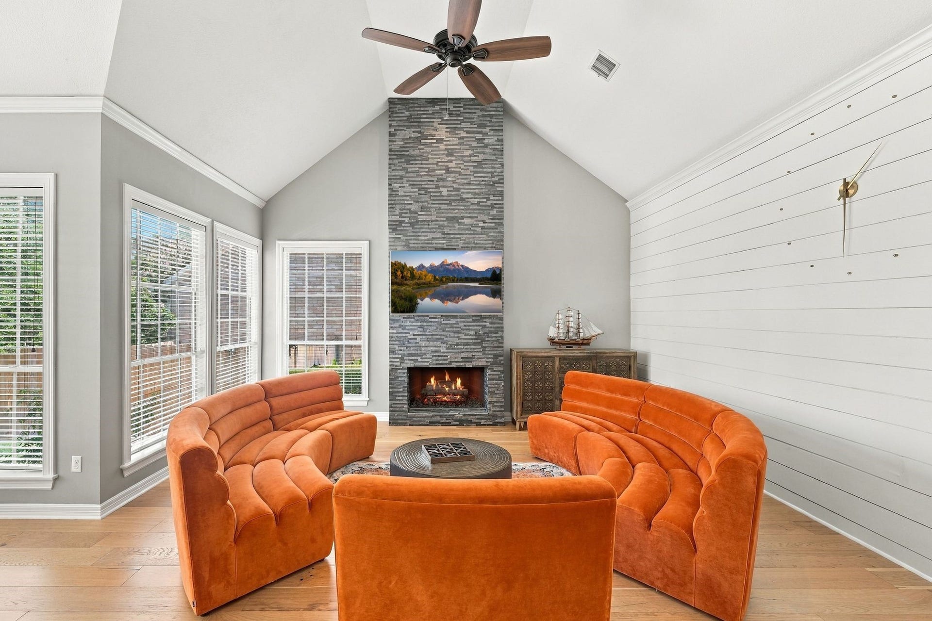 22 Hillside View Place, The Woodlands, TX 77381 The inviting family room features soaring ceilings, a dramatic floor to ceiling stone fireplace and walls of windows overlooking the backyard.