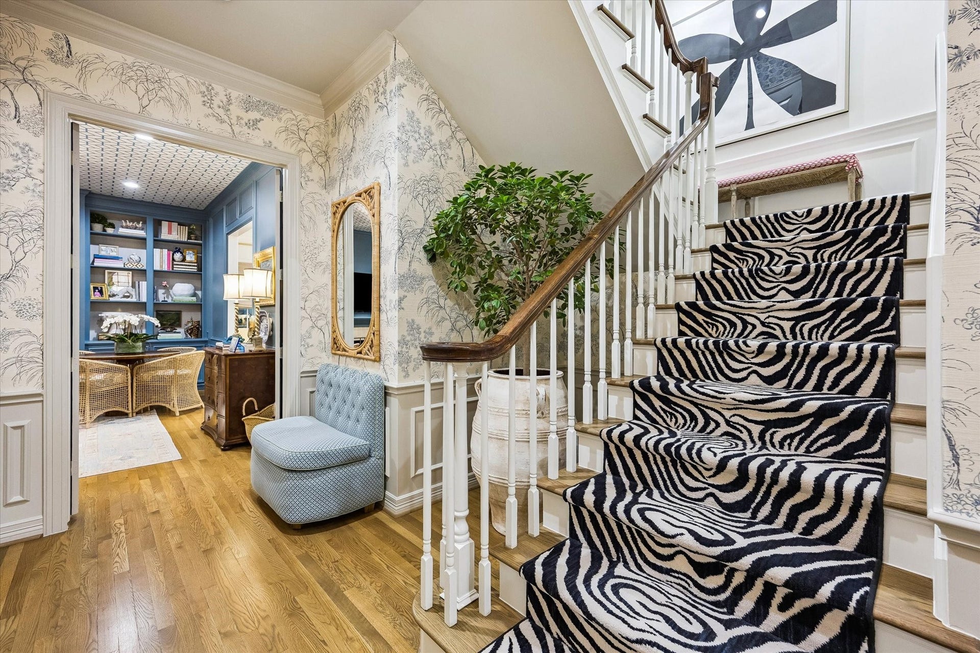 19 E Briar Hollow Lane, Houston, TX 77027 A dramatically appointed STAIRCASE with its eye-catching carpet runner, wood treads, painted risers, painted spindles and stained wood railing, painted wainscoted walls - leading to the second floor Landing.