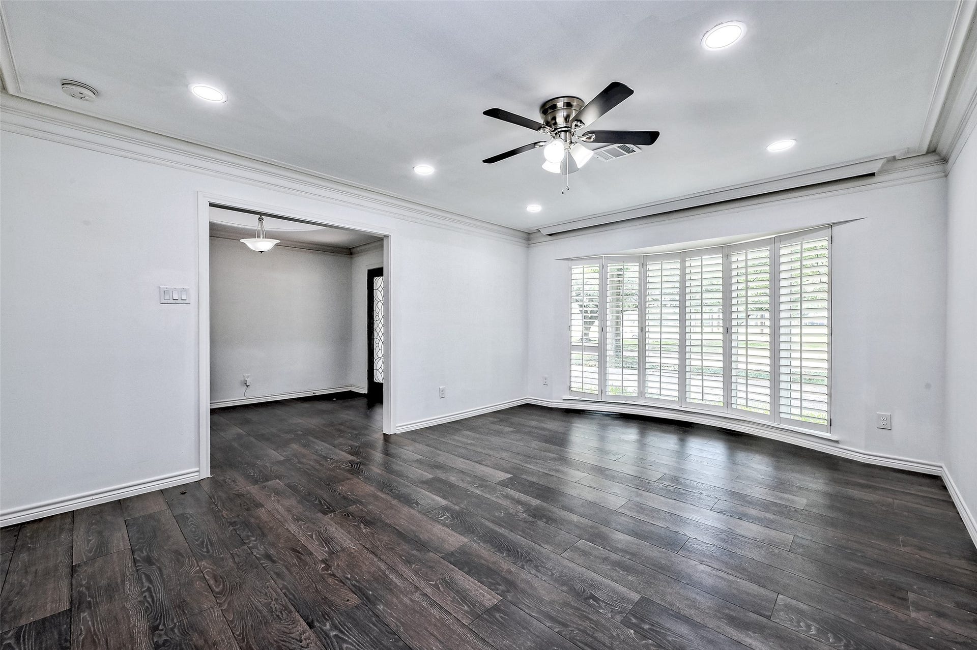 Living room is with ball window and ceiling fan, recess lights.