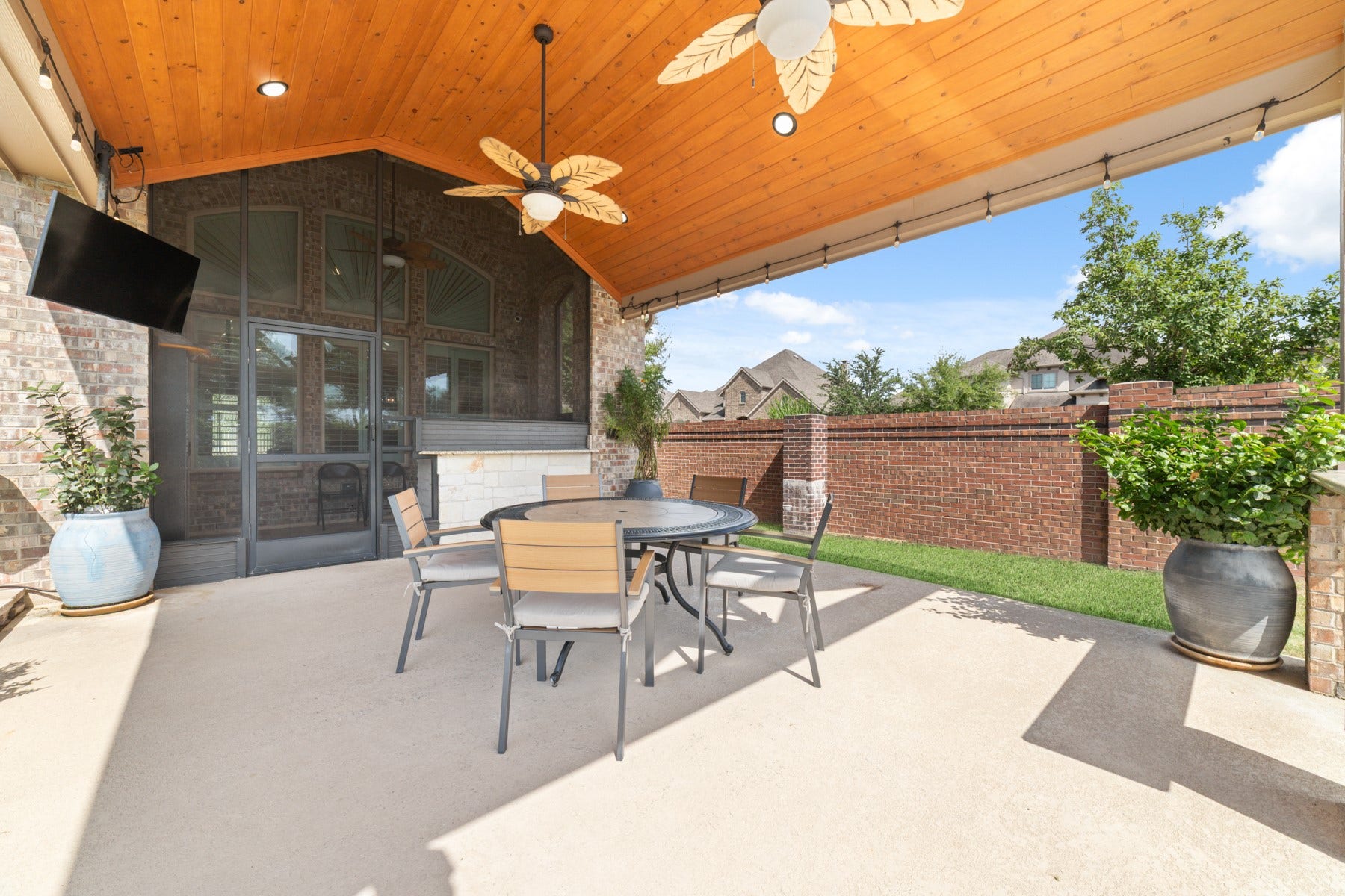 Spacious covered patio with a stylish wood-paneled ceiling perfect for outdoor dining.