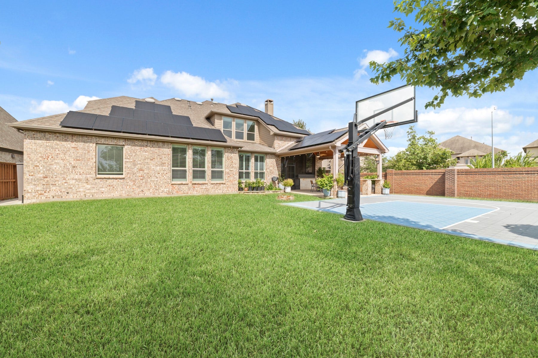 Lush lawn, and a charming brick exterior with solar panels.