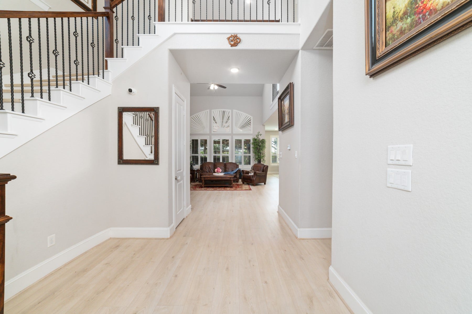 Elegant hallway with light flooring leads to a spacious living area.