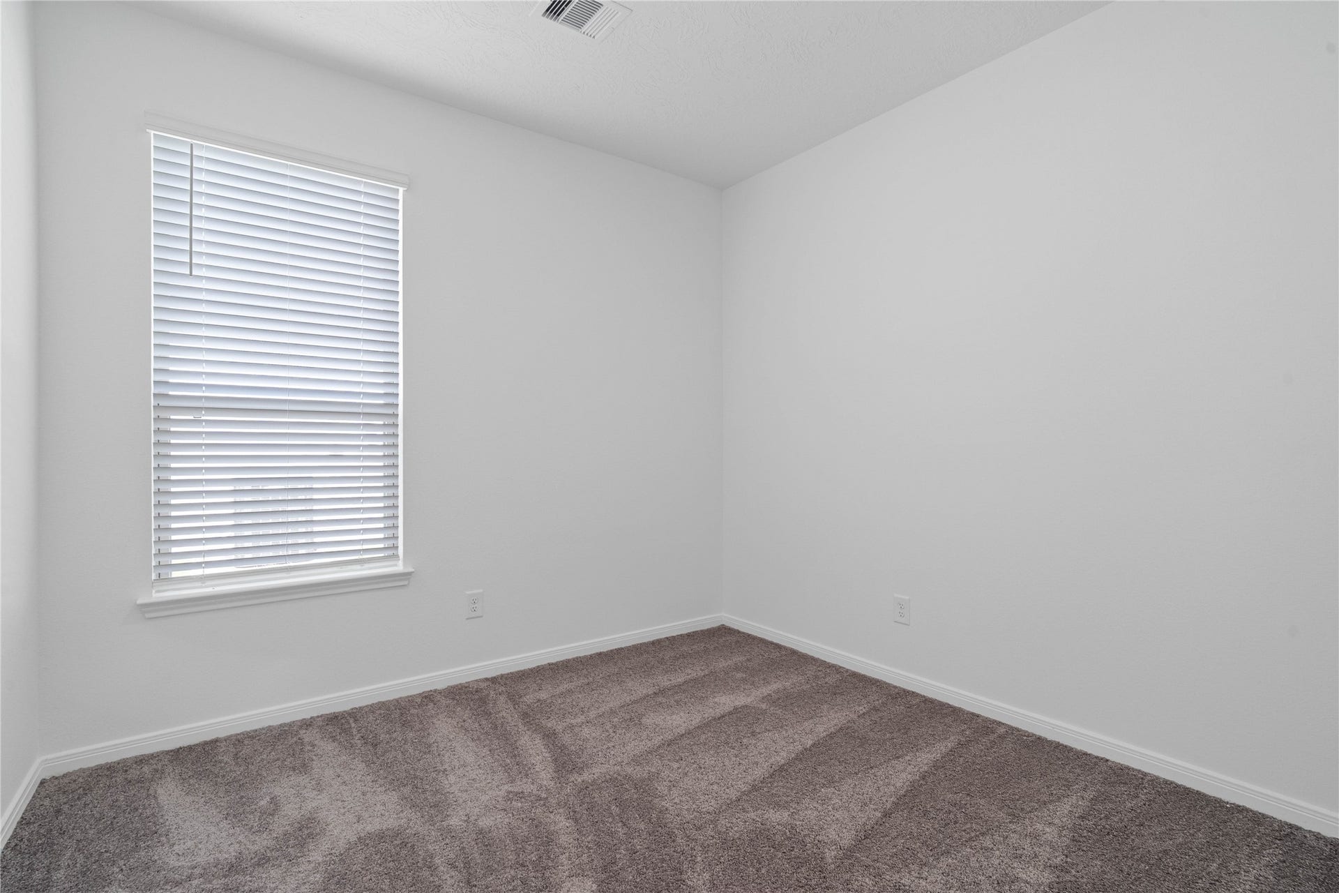 640 Appaloosa Meadow Drive, Magnolia, TX 77354 Secondary bedroom features plush carpet flooring, neutral paint, lighting, large window with fitted blinds, and an ample sized closet space.