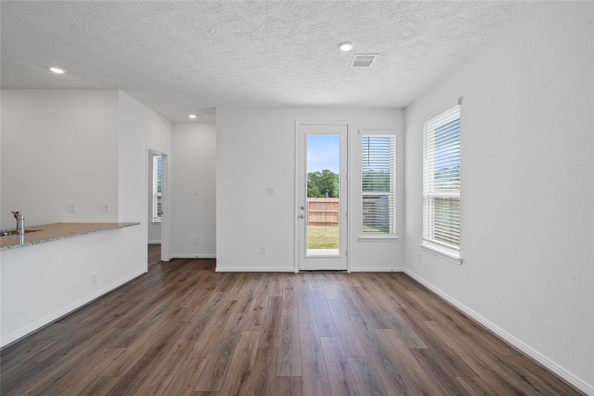 640 Appaloosa Meadow Drive, Magnolia, TX 77354 Create lasting memories around the table with family and friends in this inviting dining room! It showcases high ceilings, large window, vinyl plank flooring, recessed lighting, and access door to the backyard. Additionally, there is extra seating with the added breakfast bar to the kitchen granite countertop.