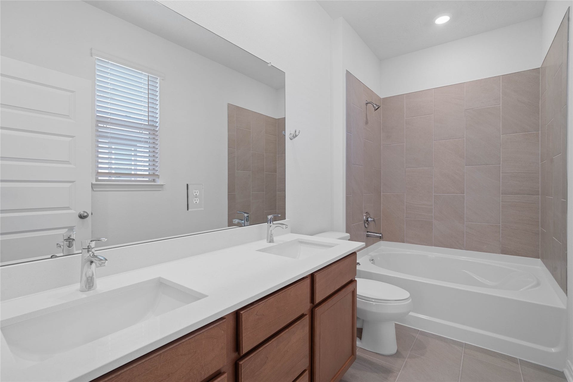 640 Appaloosa Meadow Drive, Magnolia, TX 77354 This primary bathroom is definitely move-in ready! Featuring stained cabinets with light countertops, dual vanities, tub/shower combination with tile surround, all with sleek and modern finishes.