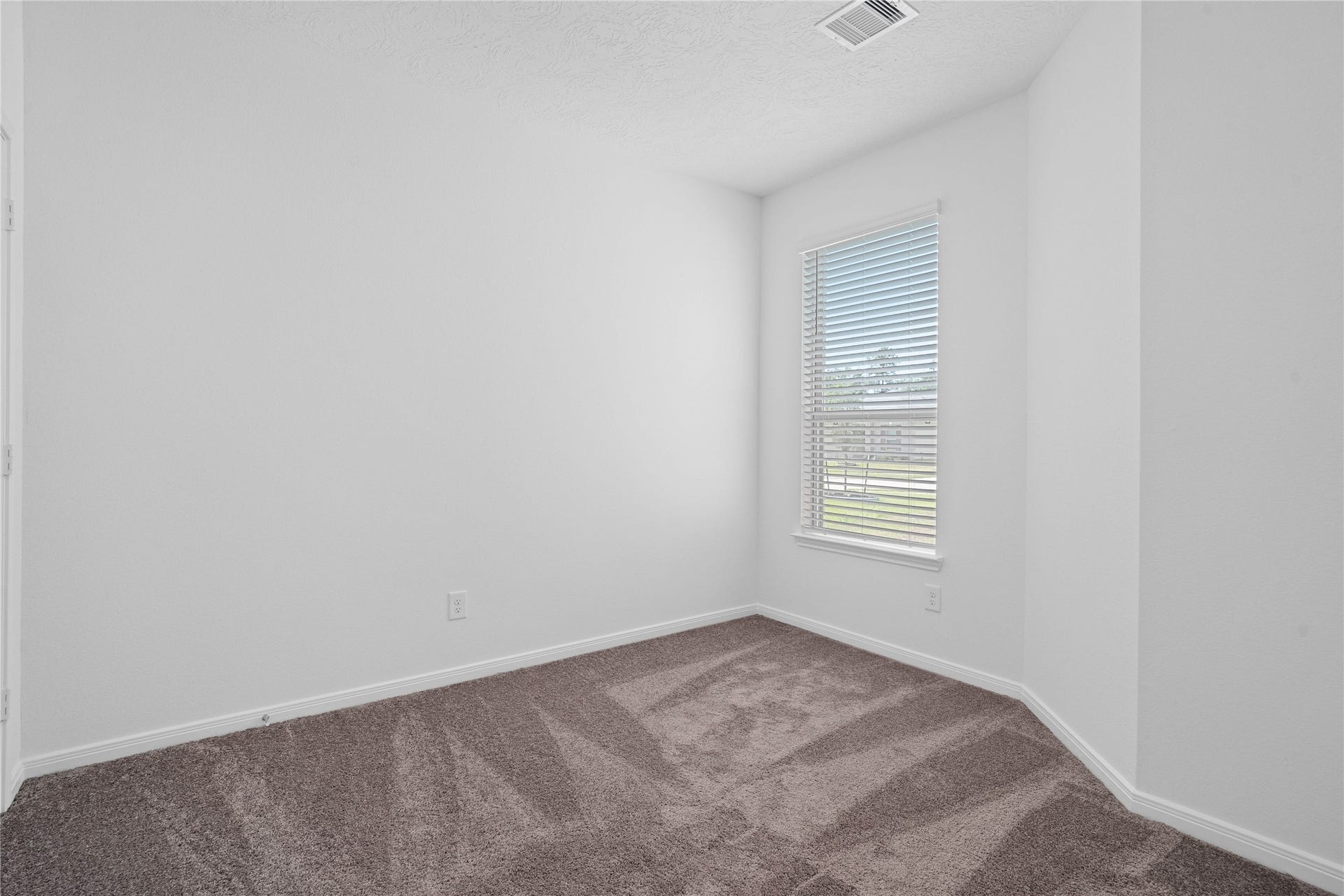 640 Appaloosa Meadow Drive, Magnolia, TX 77354 Tucked peacefully in the front of the home, this secondary bedroom features plush carpet flooring, neutral paint, recessed lighting, large window with blinds, and a walk-in closet.