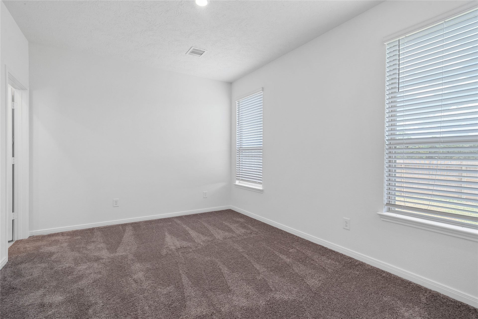 640 Appaloosa Meadow Drive, Magnolia, TX 77354 Come and unwind after a long day in this magnificent primary suite! This spacious room features plush carpet flooring, neutral paint, high ceilings, recessed lighting, and large windows fitted with blinds!